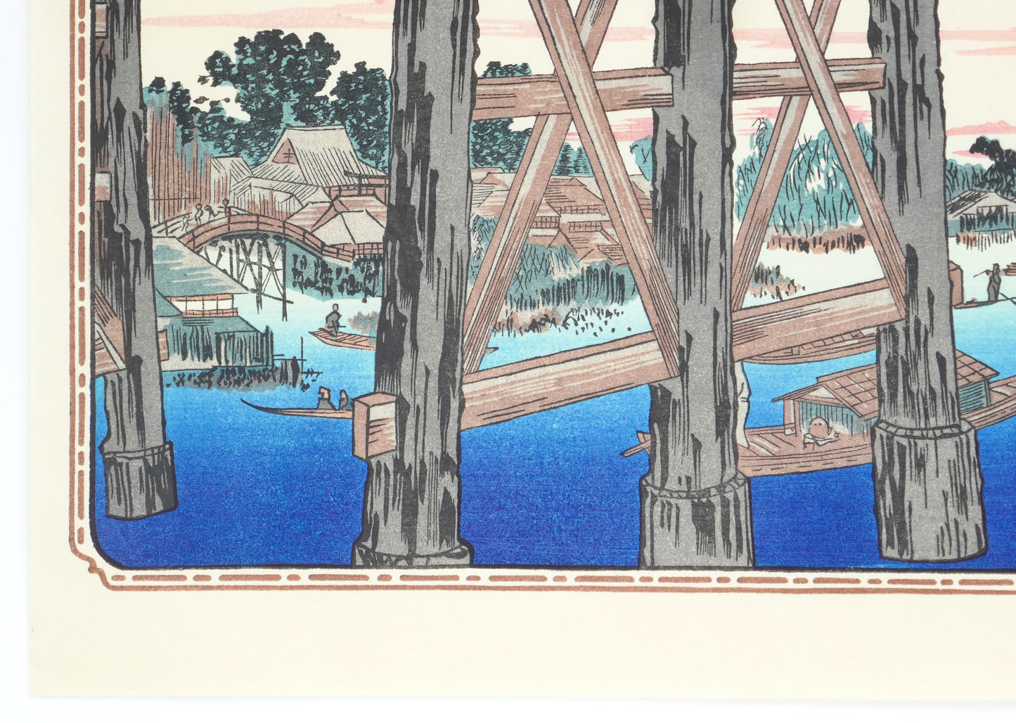 Détail du bas gauche de l’estampe montrant les piliers en bois du pont Ryōgoku, une barque avec deux passagers et des maisons traditionnelles japonaises en arrière-plan.
