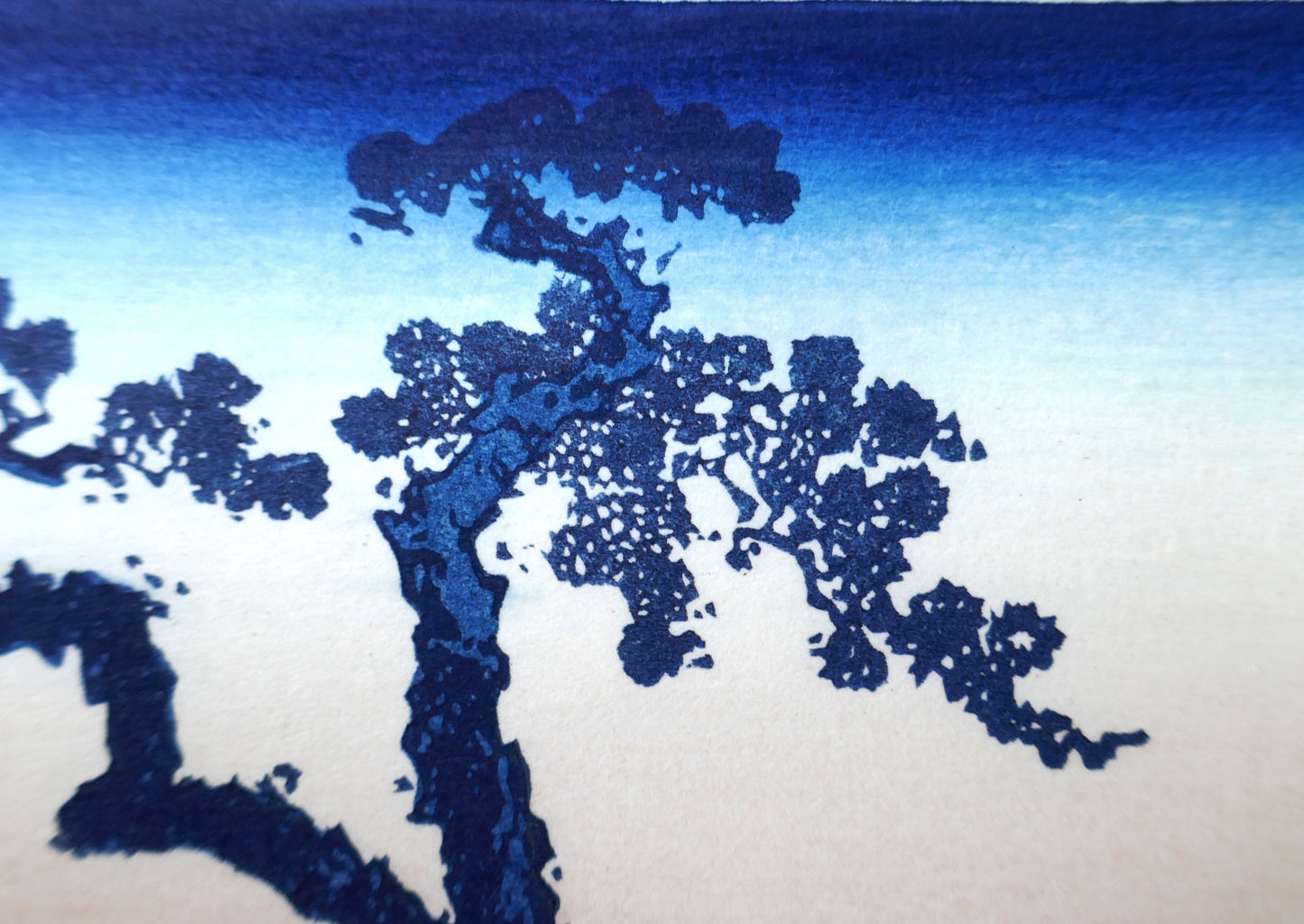 Détail estampe Hokusai 36 vues du Mont Fuji Le lac Suwa dans la province de Shinano, reproduction Shōwa, branches sombres sur ciel dégradé bleu et blanc