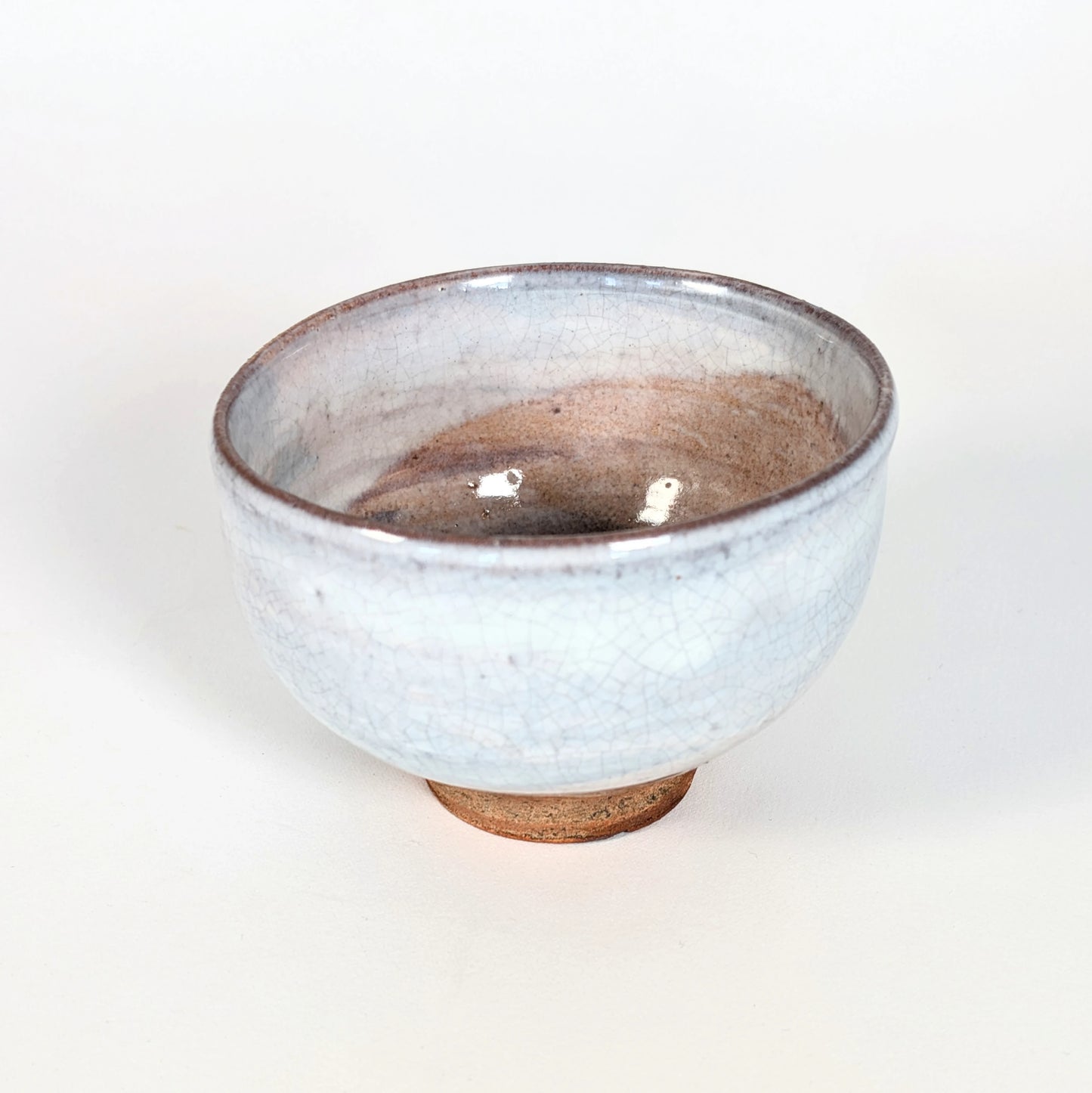 Intérieur d’un chawan japonais pour le matcha, bol à thé en céramique avec glaçure craquelée et nuances issues de la cuisson.