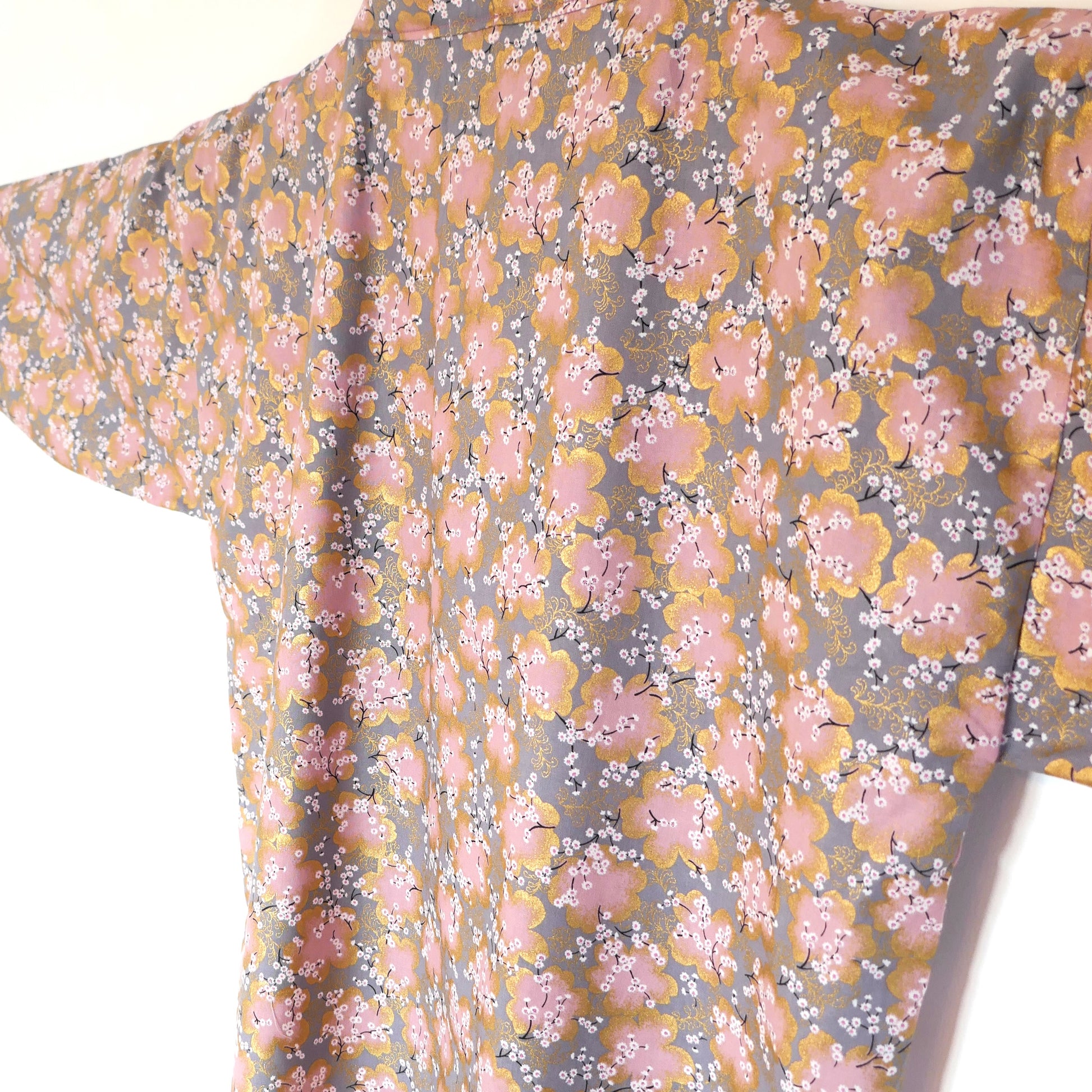 Détail lumineux du dos du haori en tissu japonais doré et rose clair