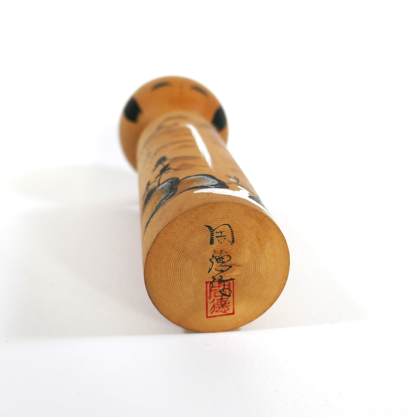 Base d’une kokeshi ancienne avec signature et seau rouge – artisan inconnu