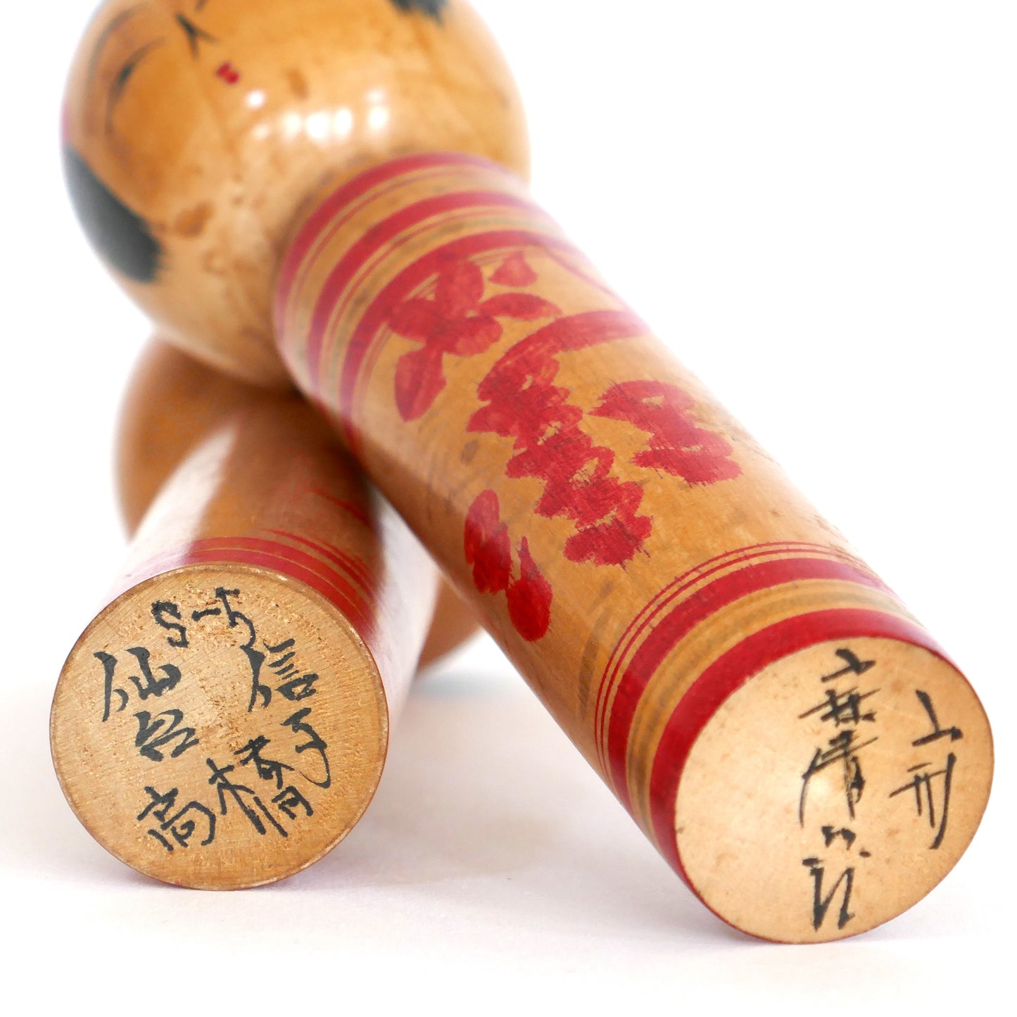 Signatures gravées sous deux kokeshi : Ogasawara Nobuko et Kobayashi Seijurō.