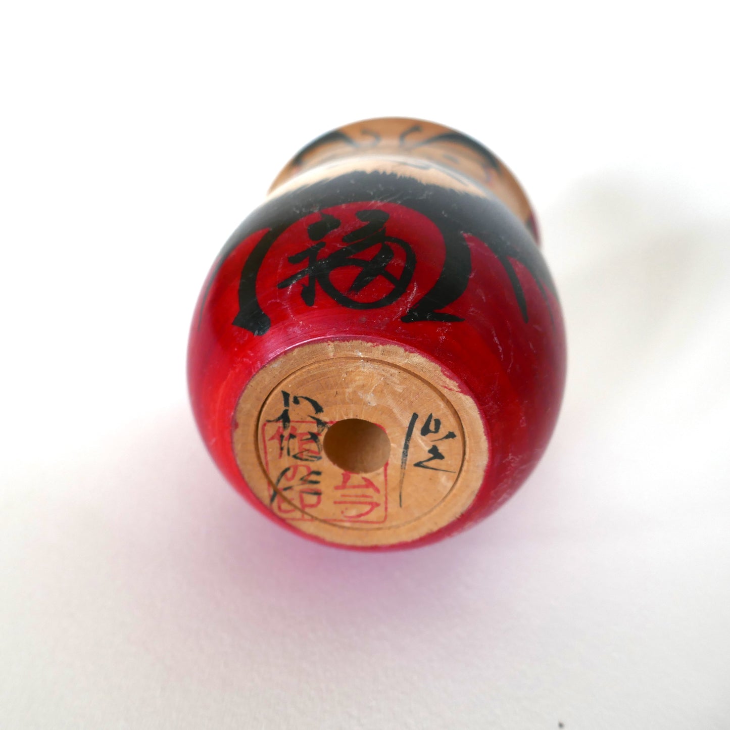Base d'une kokeshi Daruma vintage de l’ère Shōwa, signée Kawamura avec sceau en katakana de la préfecture de Miyagi