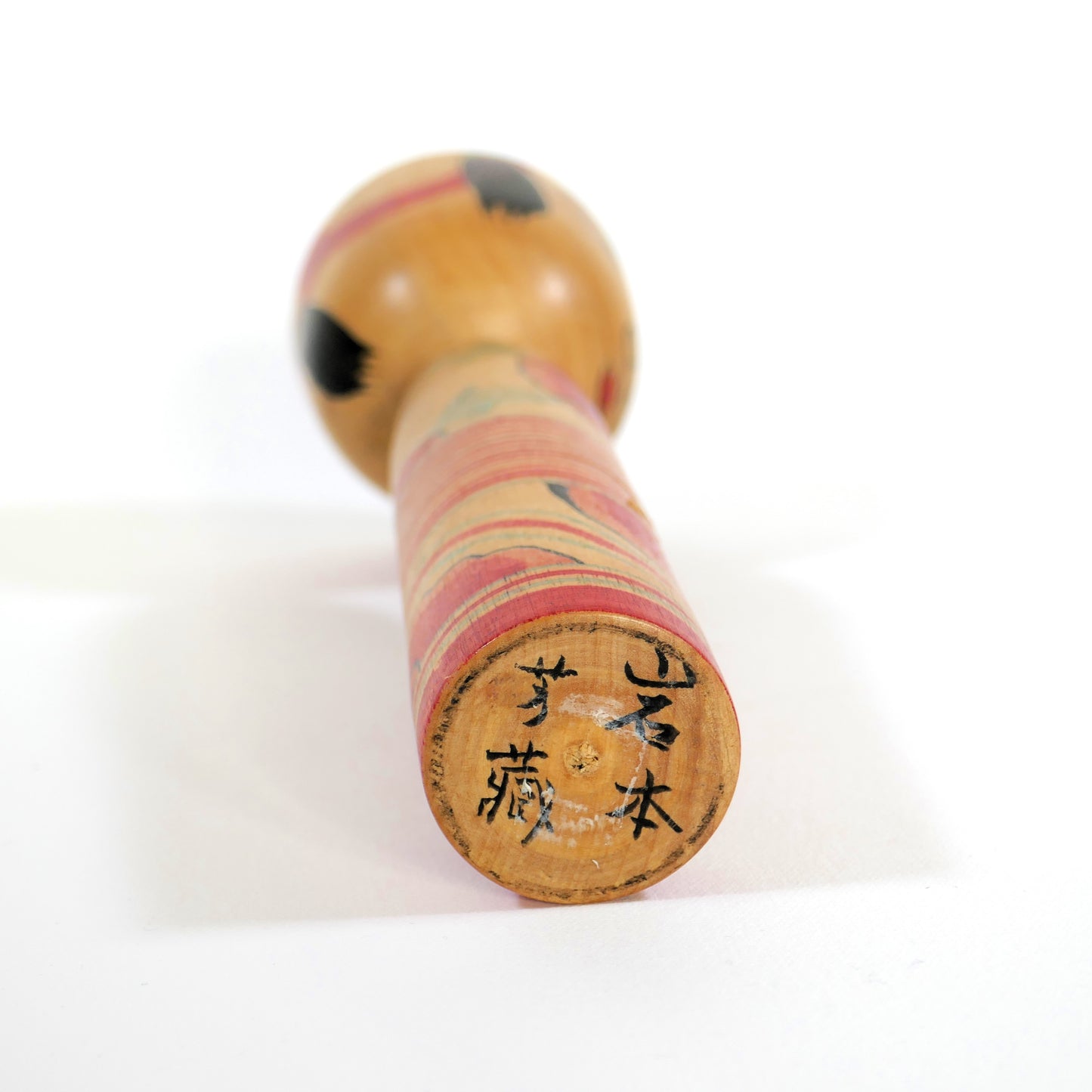 Base en bois d'une kokeshi Nakanosawa signée par l'artisan Iwamoto Yoshizō
