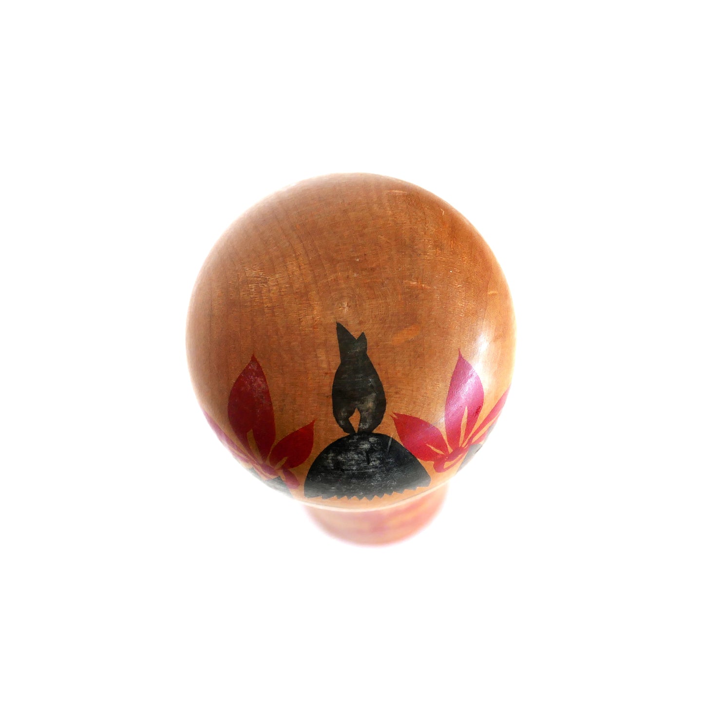 Vue du dessus d’une kokeshi Naruko montrant la coiffure peinte à la main.