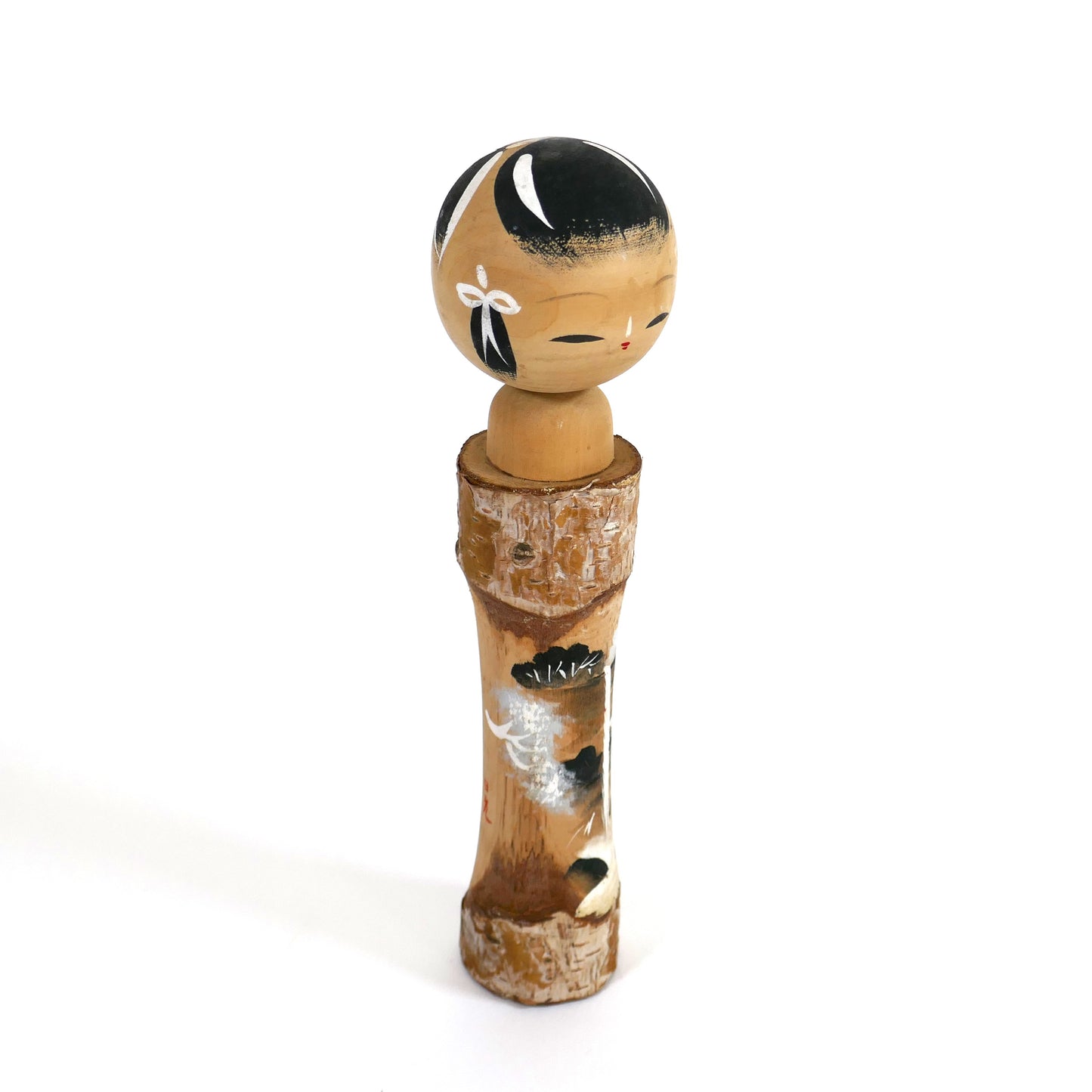 Kokeshi artisanale japonaise de Nikkō, vue de côté montrant le motif peint sur bois.