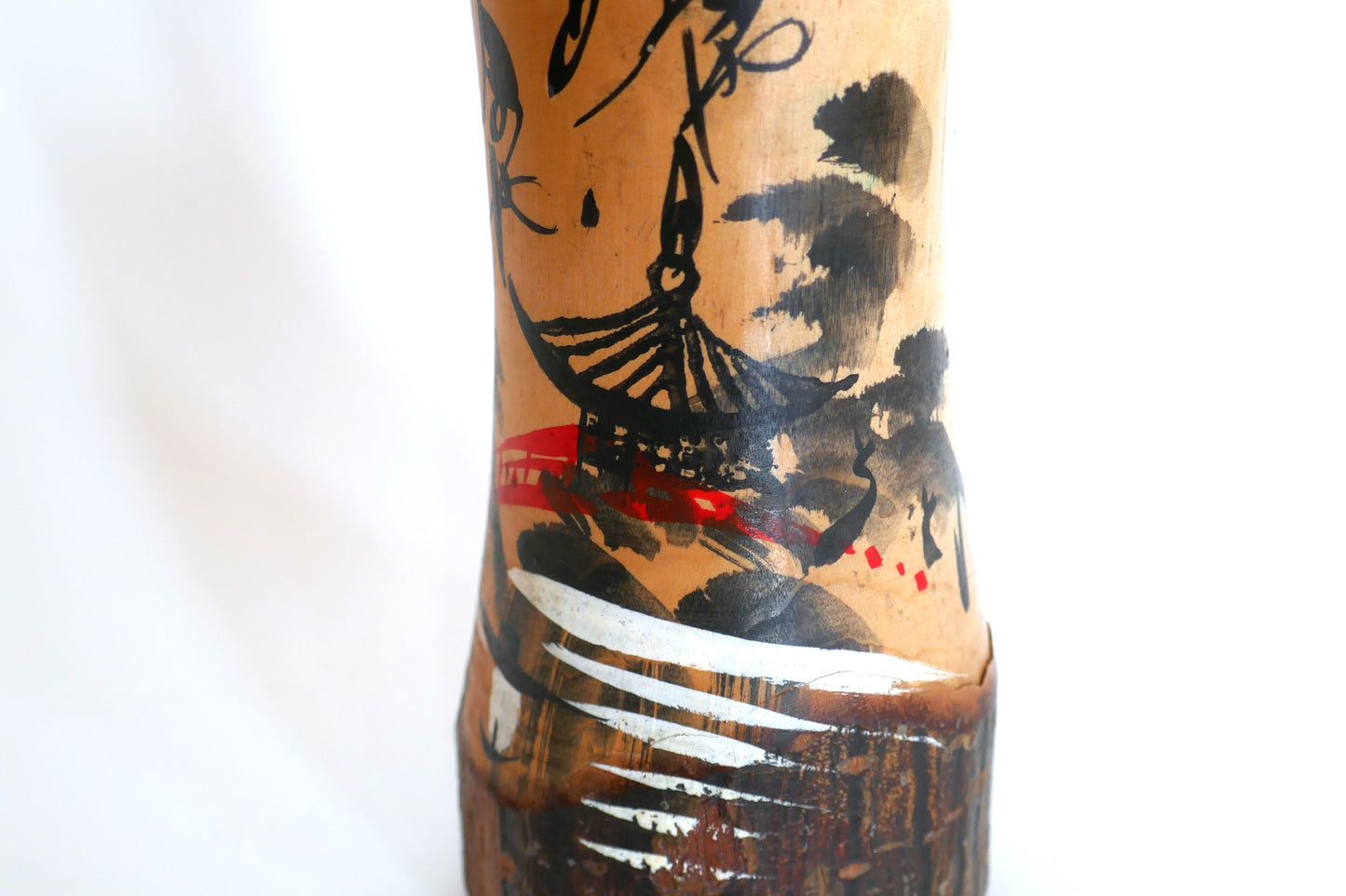 Détail d’un temple traditionnel japonais sur une kokeshi peinte – pagode noire, forêt et pont rouge sur fond de montagne