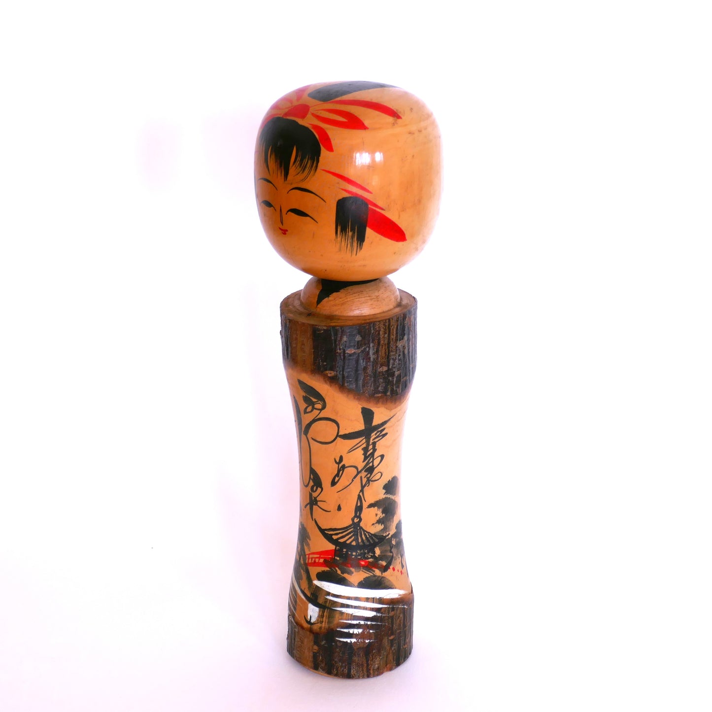 Vue de profil gauche d’une kokeshi omiyage ancienne – décor montagnard peint et signature calligraphiée de l’artisan Iwasaki