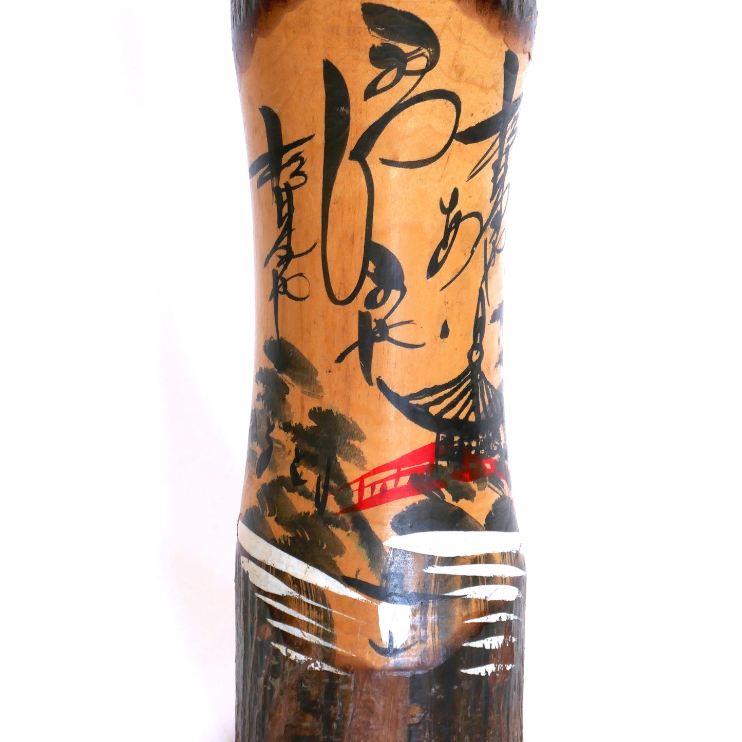 Détail d’une kokeshi souvenir peinte à la main – paysage de montagne, pont rouge et pagode avec calligraphie japonaise stylisée