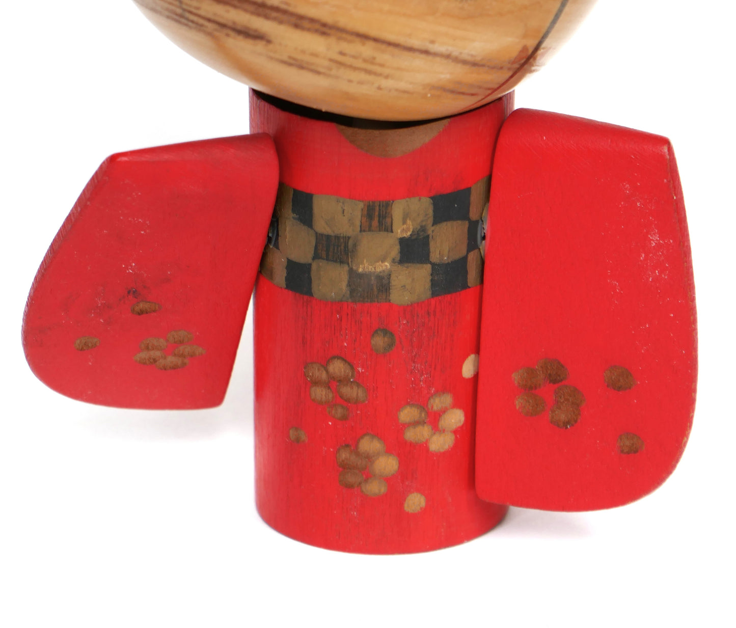 Motifs floraux dorés sur le kimono rouge et détails de la ceinture à damier.
