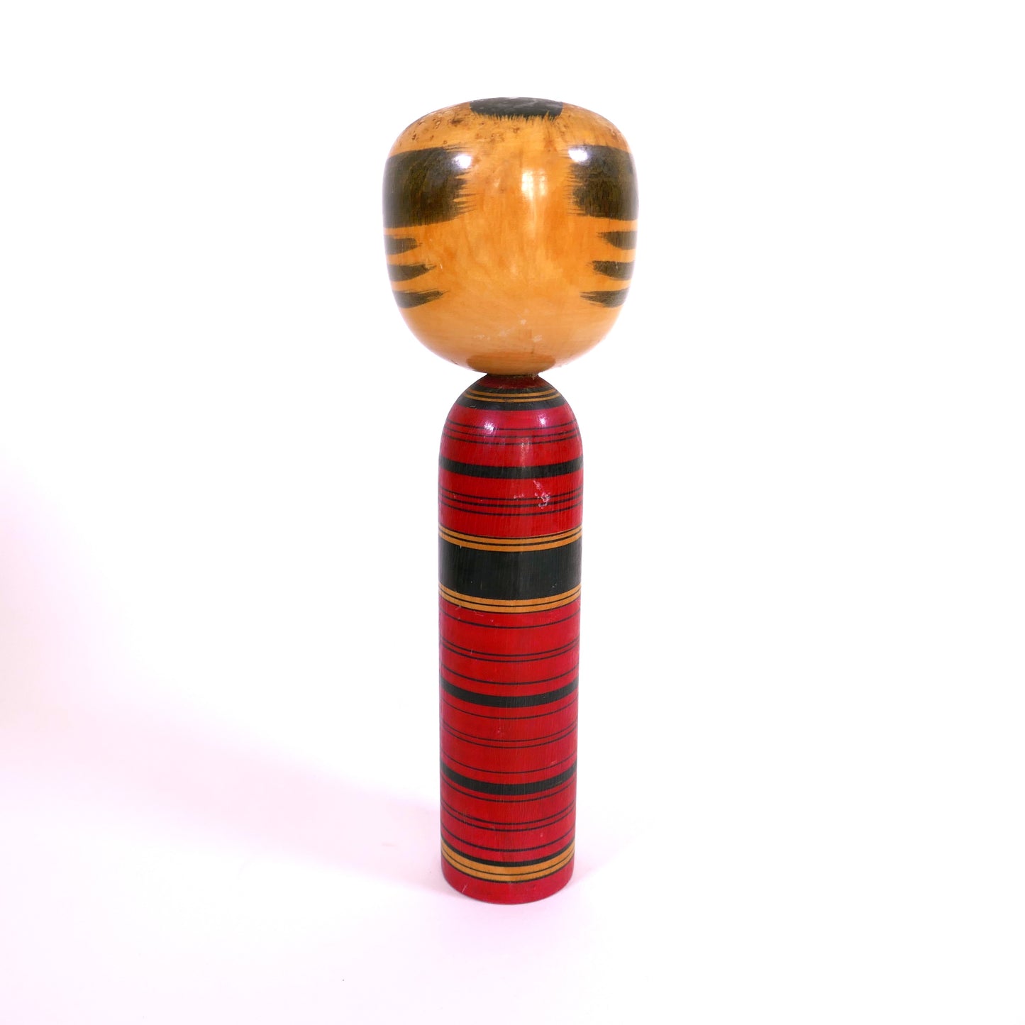 Vue arrière d’une kokeshi moderne (shingata) peinte en rouge par Katsumi Sasaki.