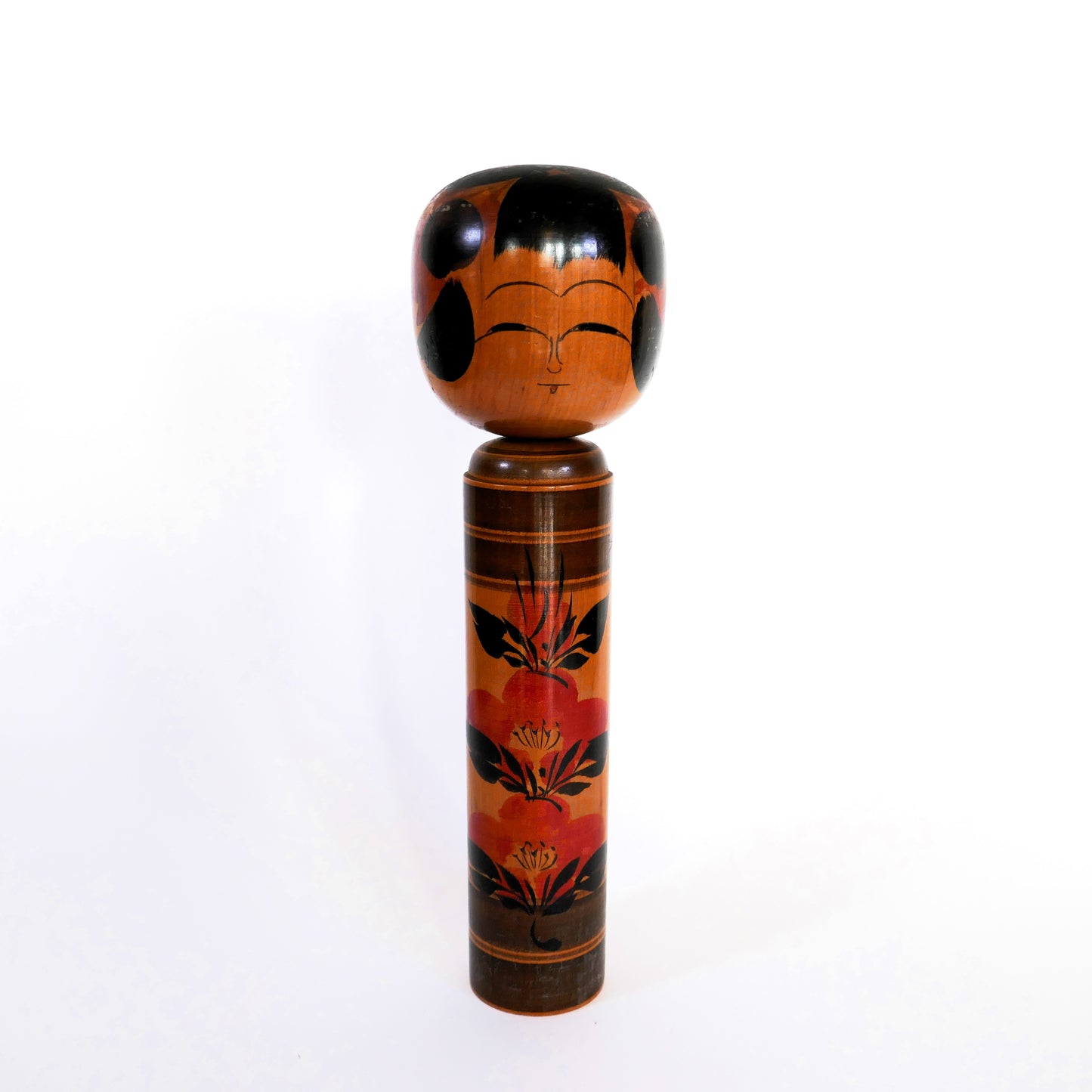 Kokeshi japonaise Shingata artisanale par Kiyohara Takao, décor peint de camélias rouges et feuilles noires, vue de face.