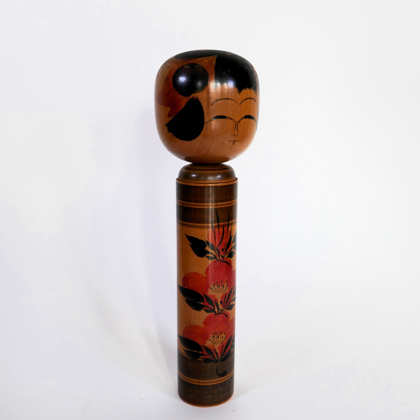 Kokeshi japonaise Shingata artisanale par Kiyohara Takao, décor de camélias rouges et feuilles noires, vue de profil.