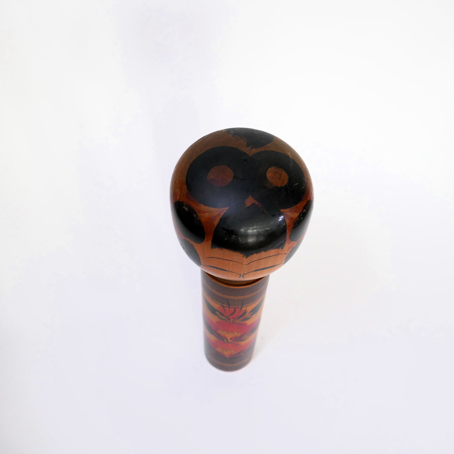 Kokeshi japonaise Shingata artisanale par Kiyohara Takao, vue du dessus avec coiffure peinte et motif floral de camélia.