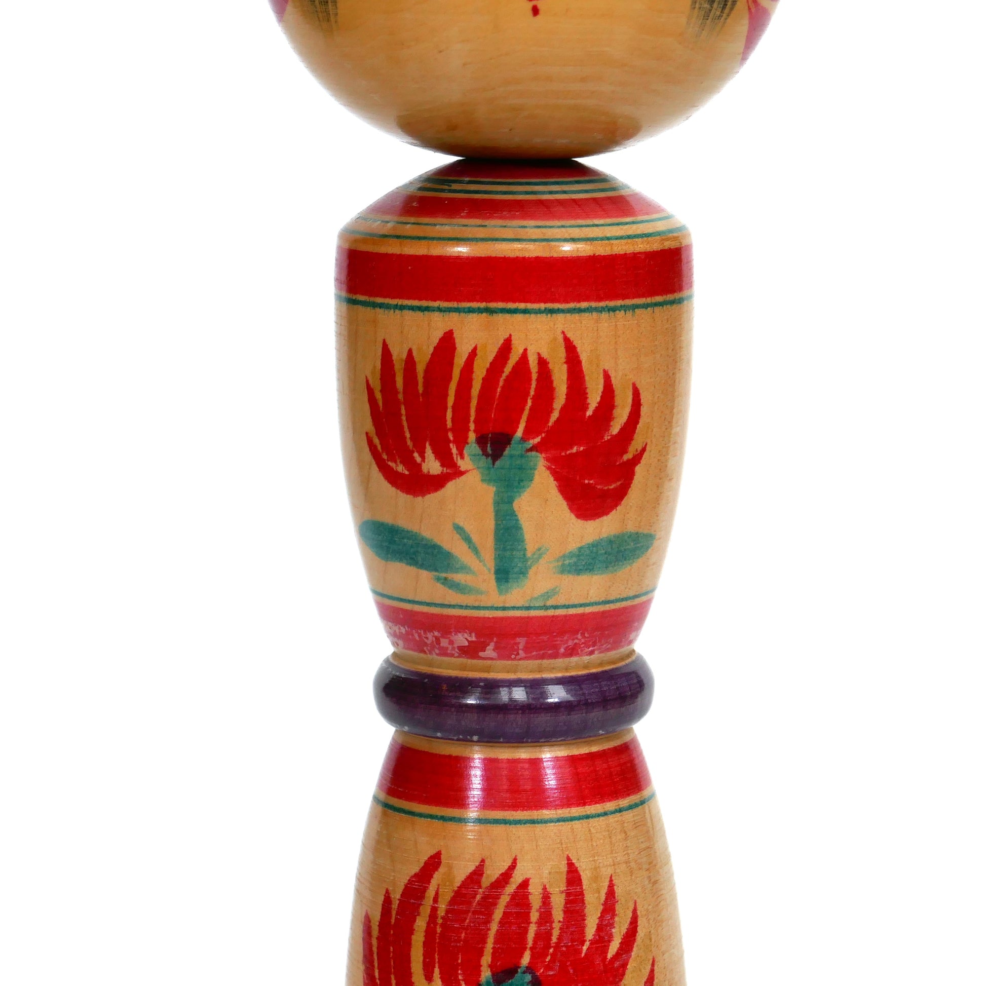 Détail du buste d'une kokeshi shingata peinte à la main avec fleurs rouges
