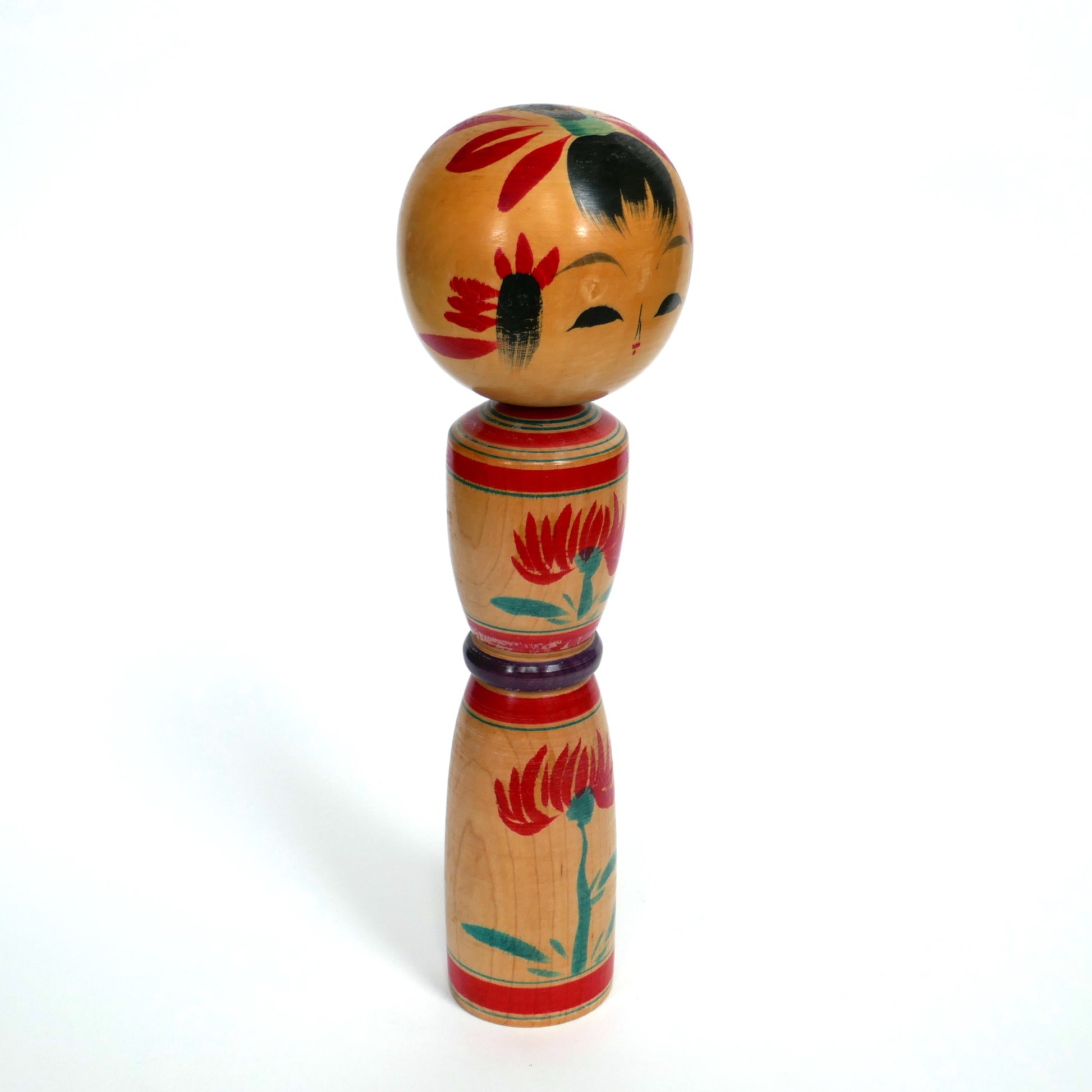Vue de profil droit d'une kokeshi traditionnelle japonaise peinte à la main