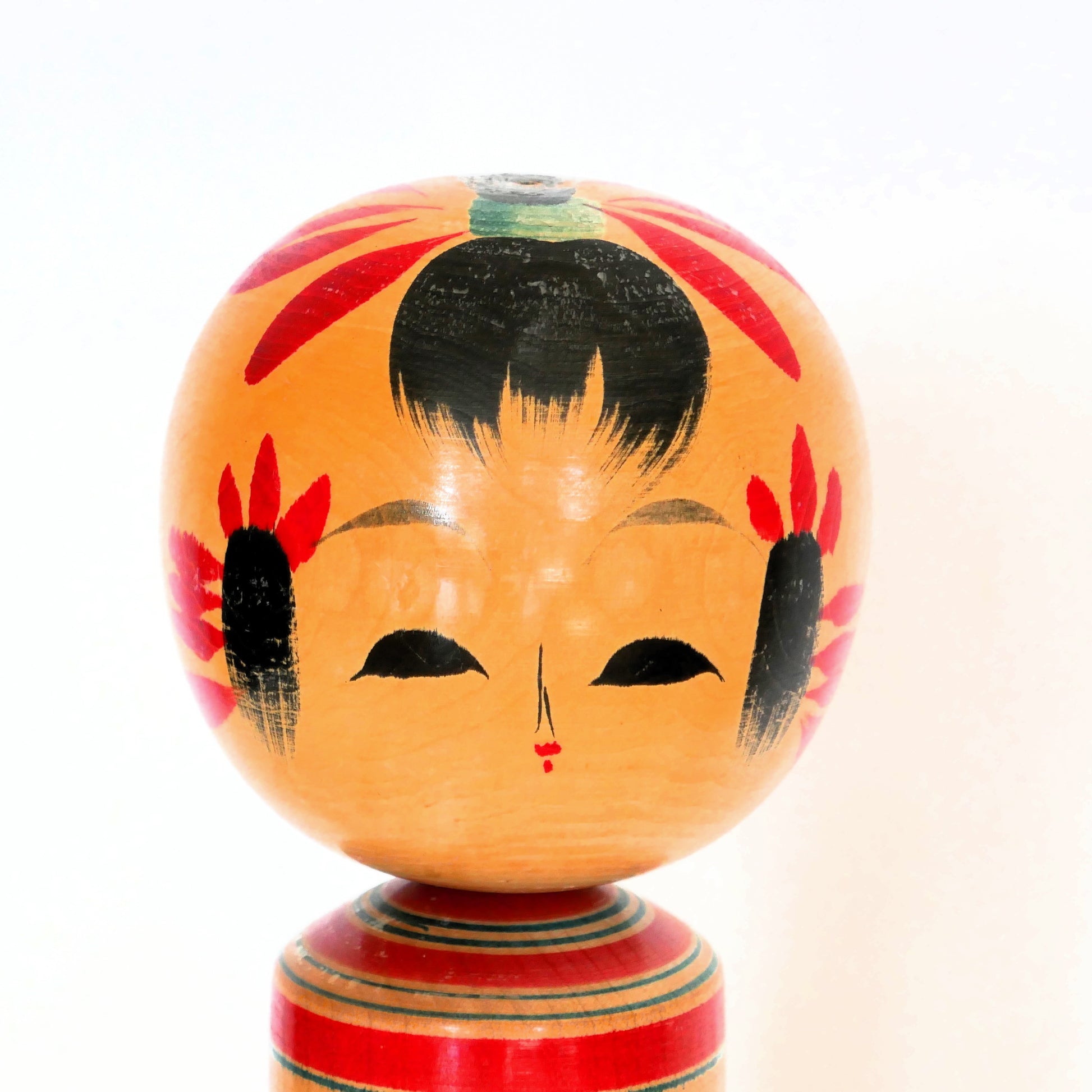 Gros plan du visage peint d'une poupée kokeshi shingata artisanale japonaise