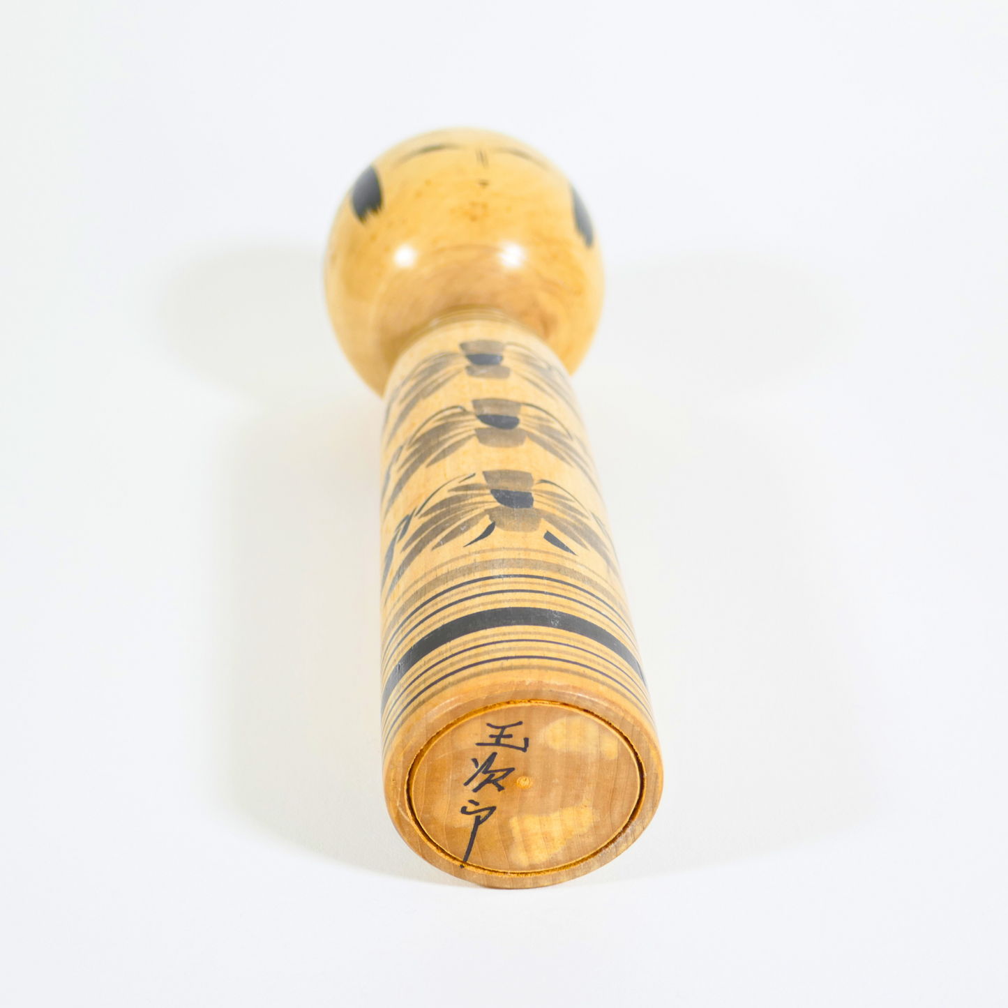Base en bois d'une kokeshi signée Murakami Tamajiro, artisan japonais