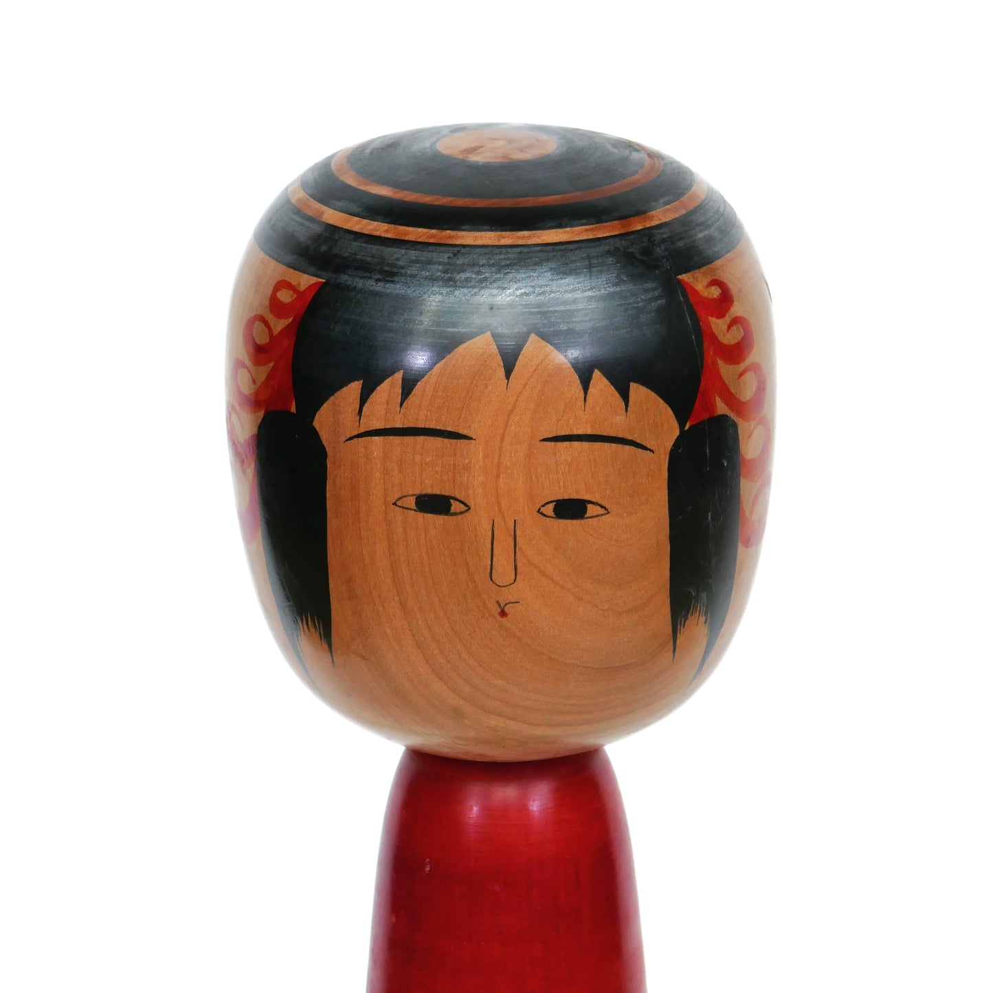 Gros plan sur le visage d'une kokeshi traditionnelle Tsuchiyu, expression douce peinte à la main, signée Abe Kazue.
