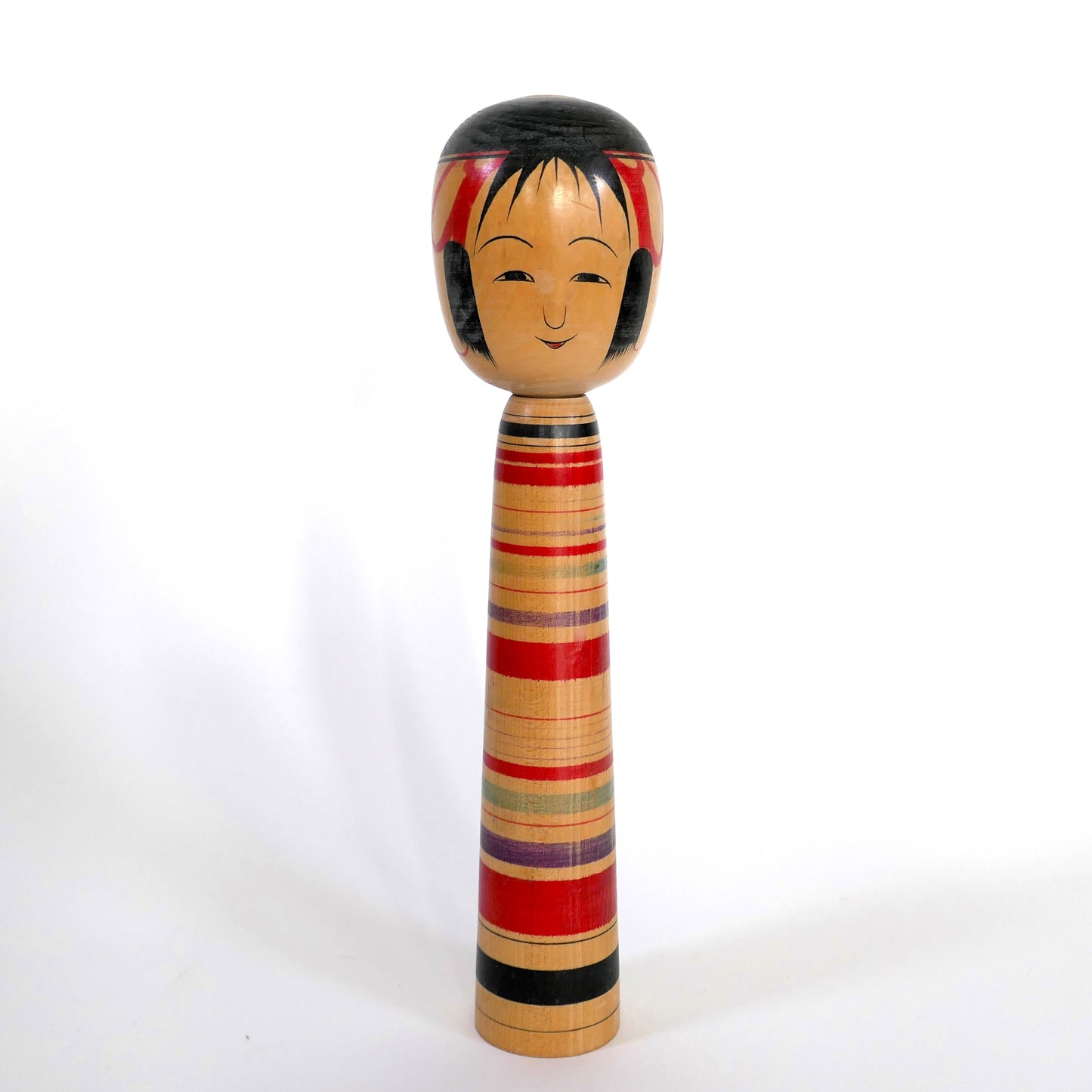 Kokeshi traditionnelle Tsuchiyu signée Tokunaga Shin’ichi, vue de face avec rayures multicolores