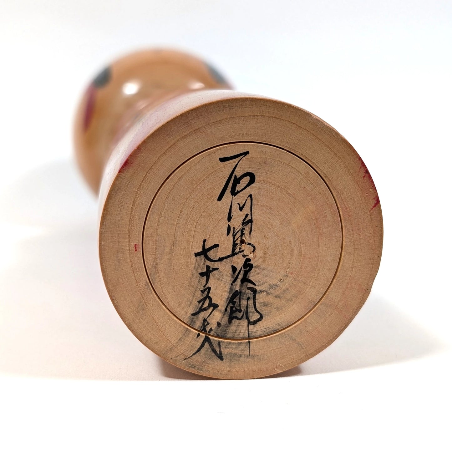Signature de l’artisan Ishikawa Tokujiro à 75 ans sur une kokeshi vintage japonaise