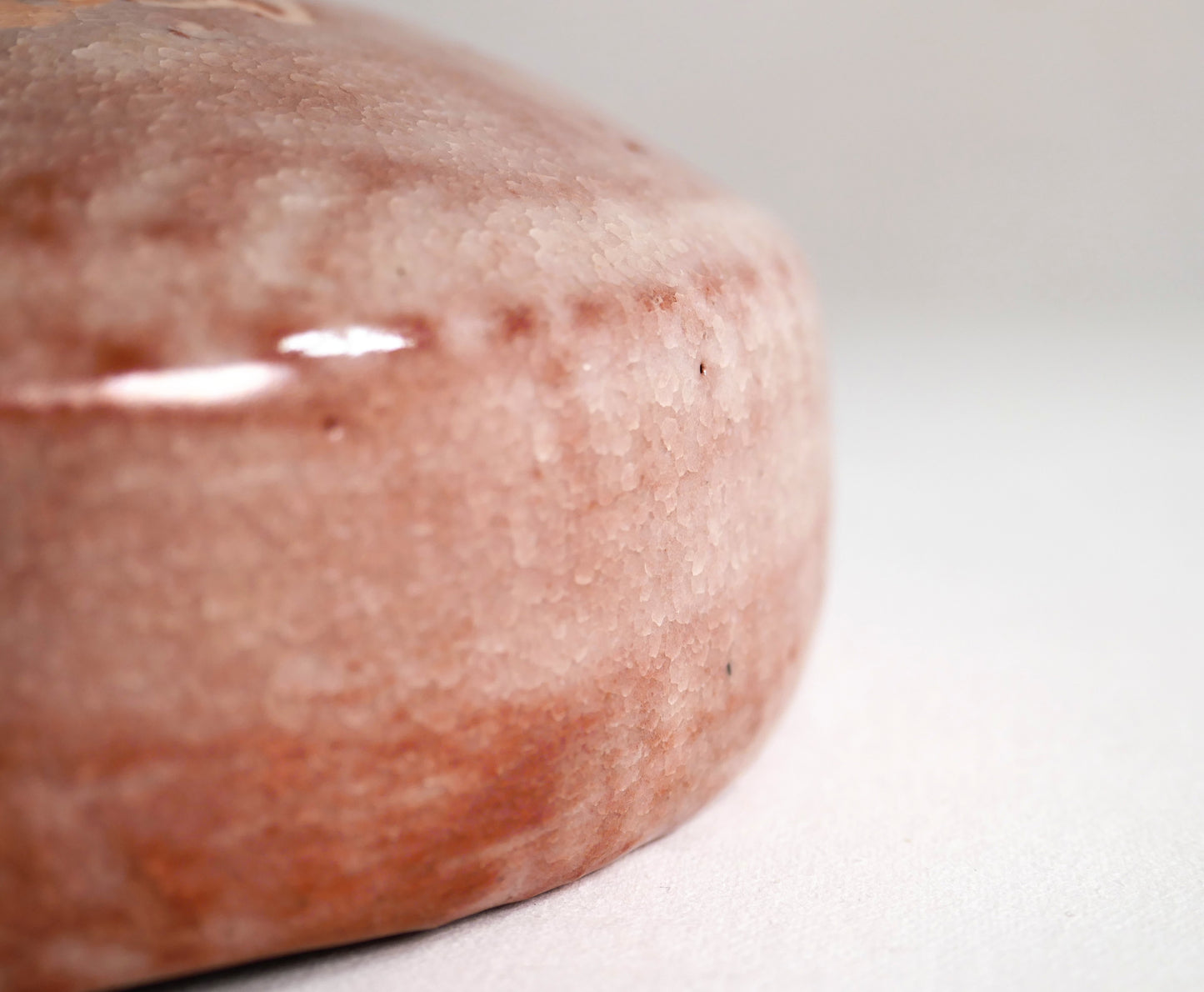 Macro de l’émail rose craquelé kanyū sur bol matcha raku, texture artisanale wabi-sabi