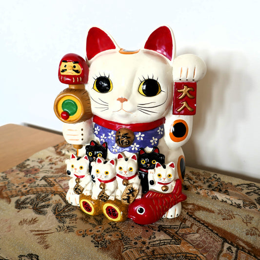 vue de face d'un maneki neko chat porte bonheur japonais kogedo mis en scene sur un obi