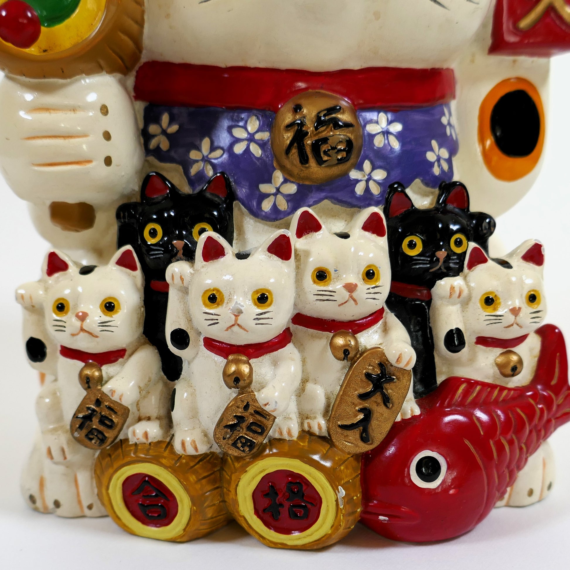 Détail des petits maneki neko et des pièces koban dorées symboles de richesse.