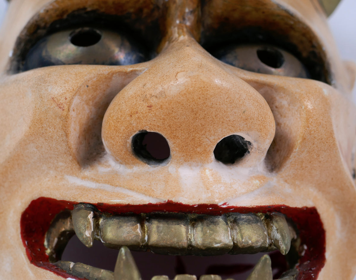 Masque Hannya en bois polychrome : vue rapprochée du nez ajouré, de la bouche rouge et des dents dorées.