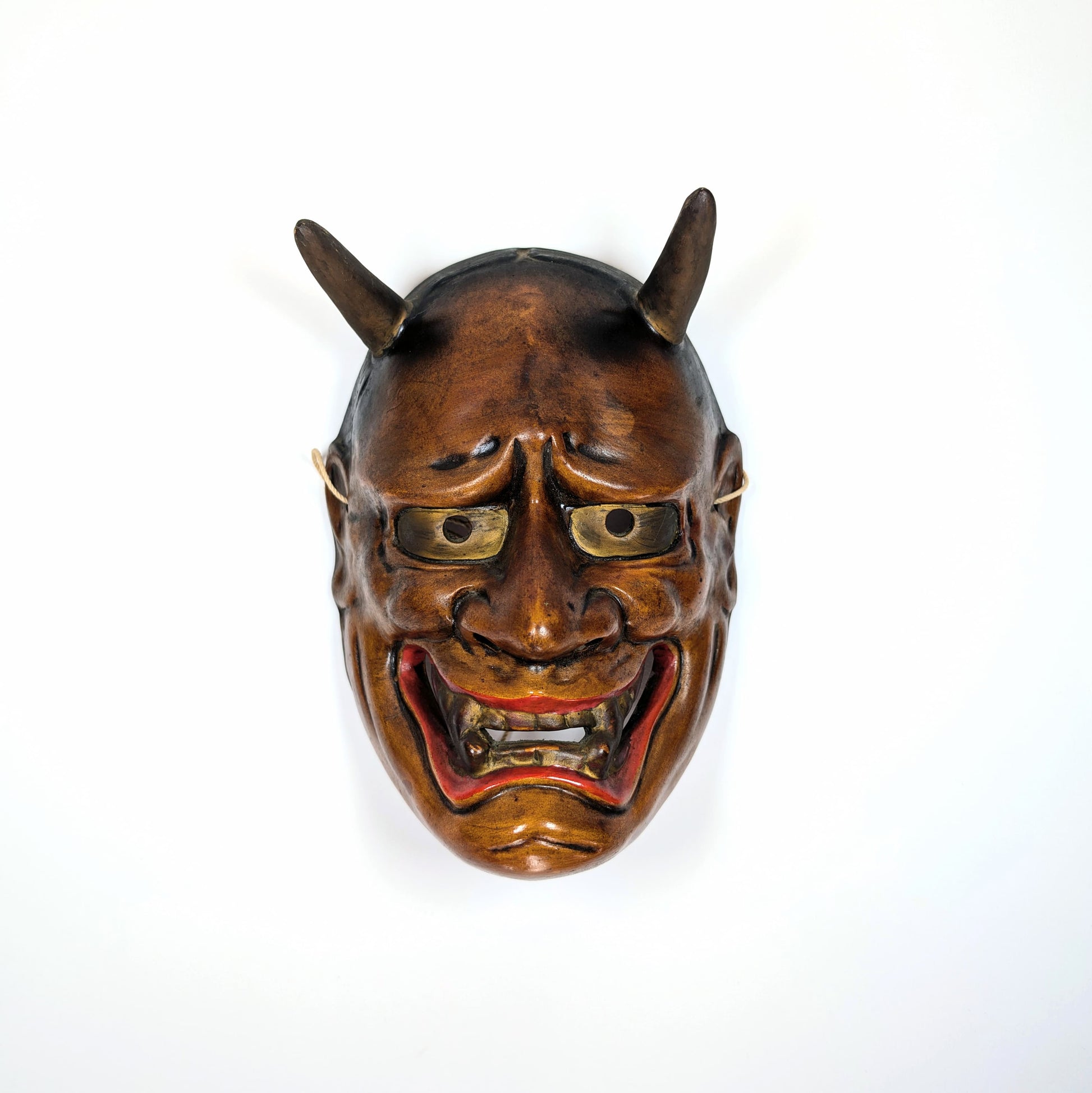 Masque japonais de théâtre Nô en céramique vu de face, éclairage dramatique traditionnel