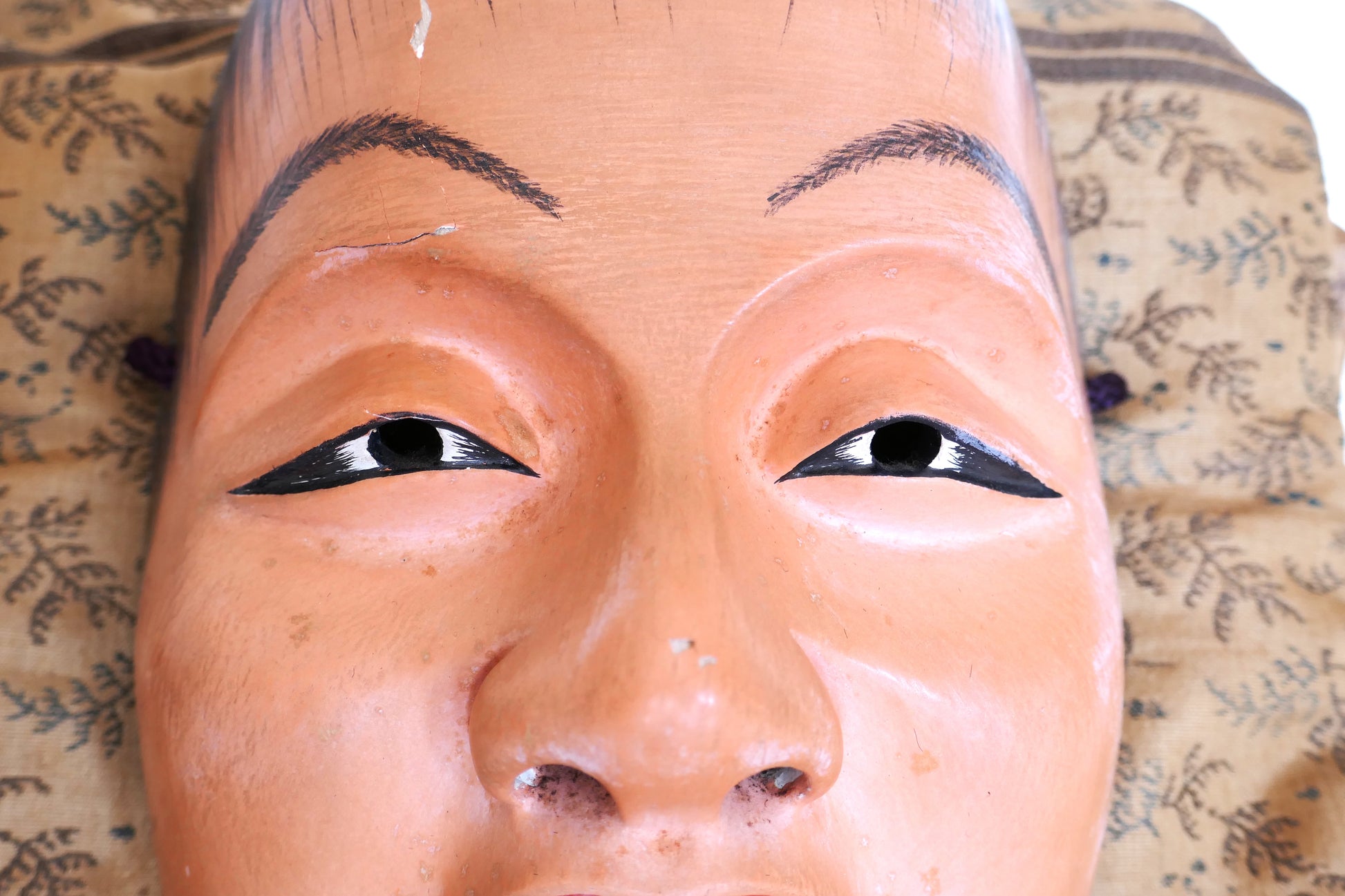 Gros plan sur les yeux du masque Nô japonais Doji – expression enfantine délicate