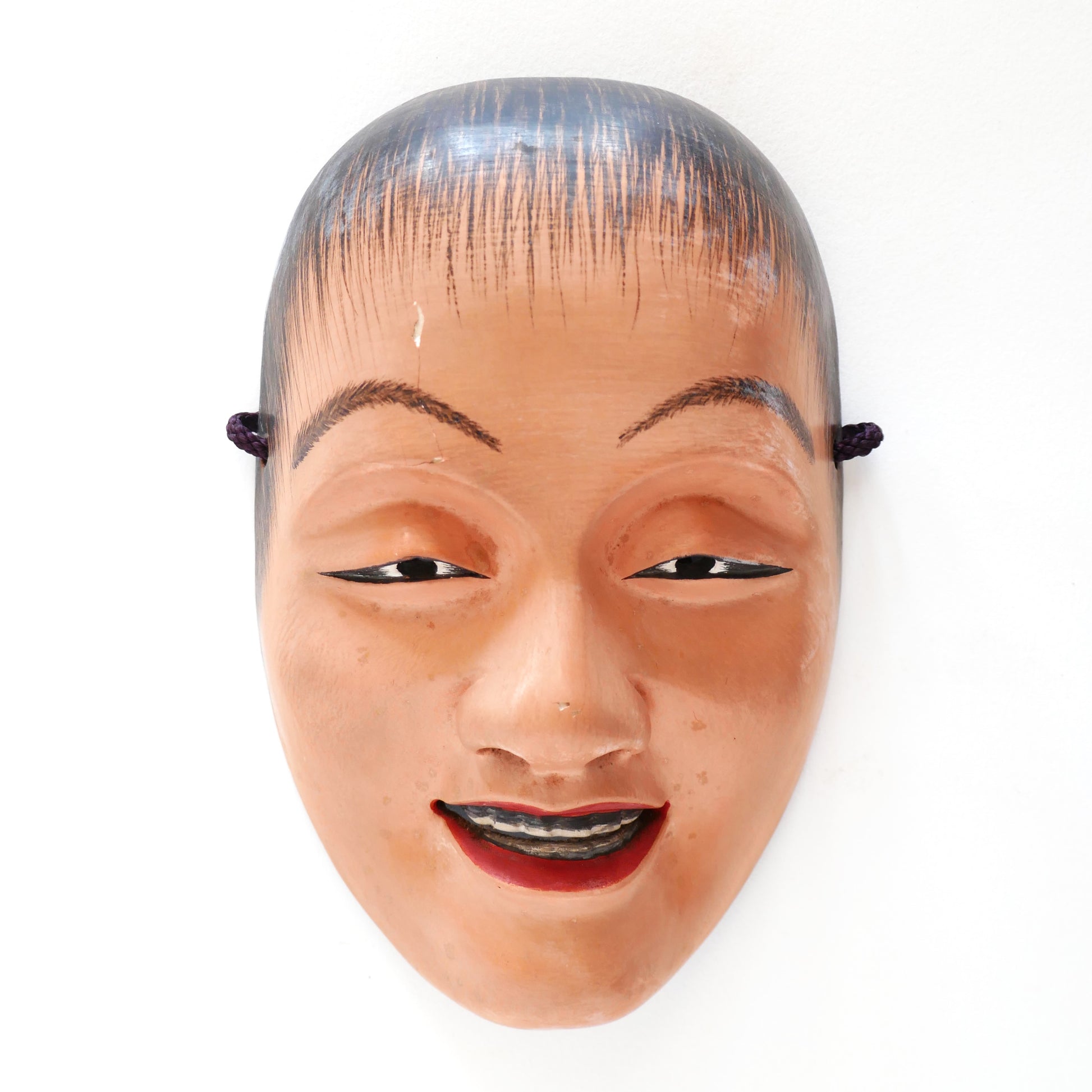 Masque Nô japonais Doji vu de face sous lumière forte – détails mis en valeur