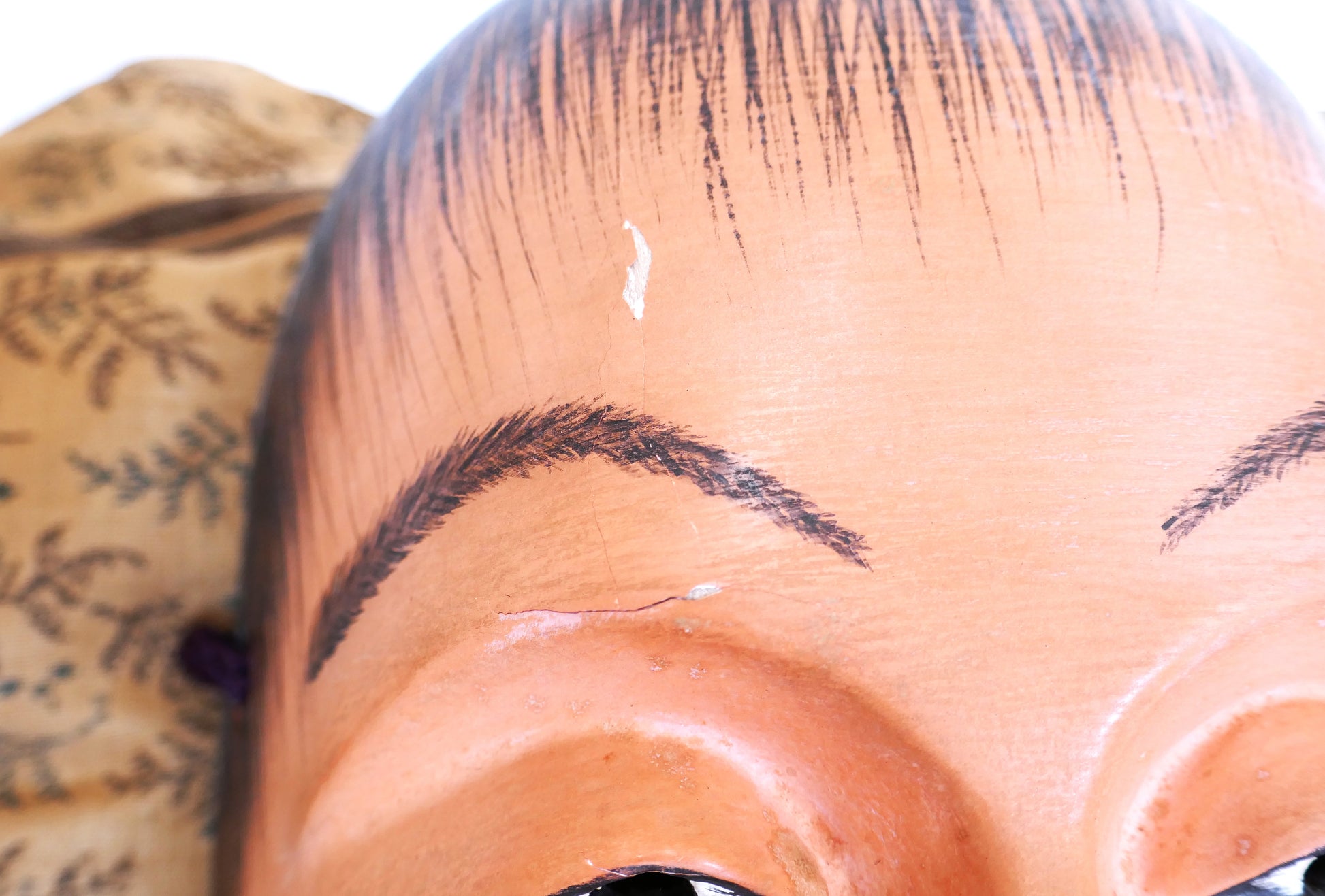 Fente visible sur le front du masque Nô Doji – état d’usage typique d’un objet vintage