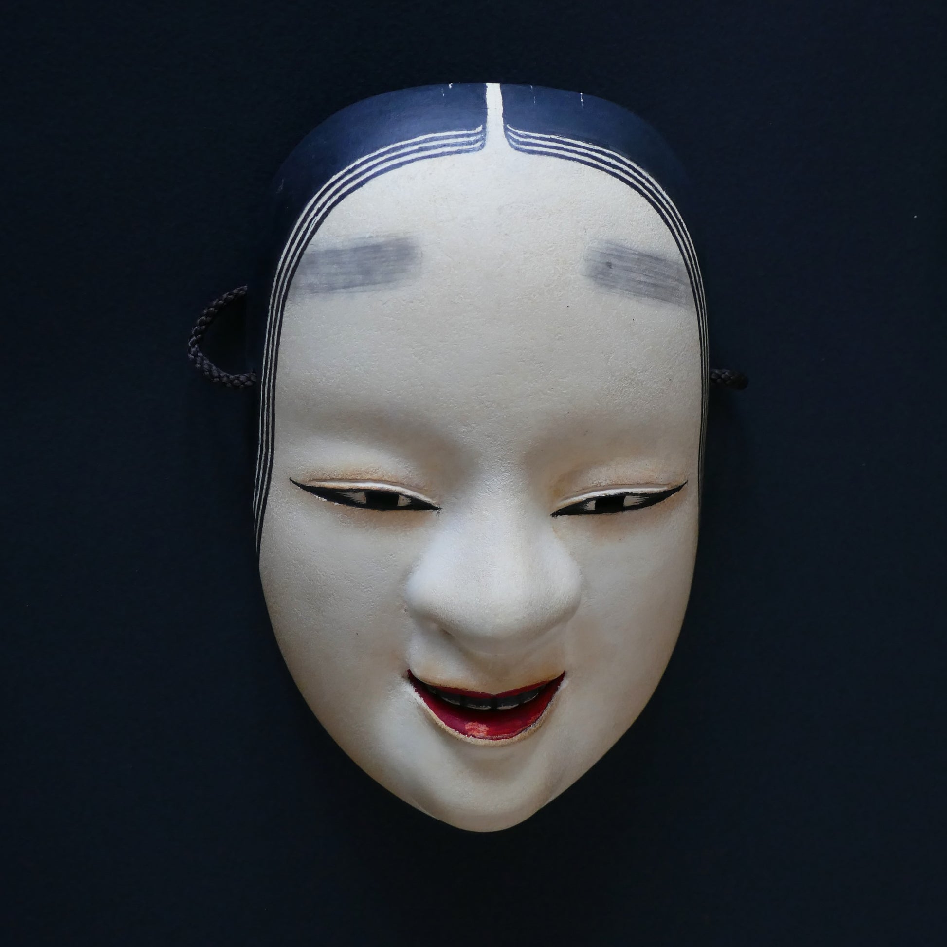 Masque Nô Ko-omote du Japon signé Keigo, représentant un visage de jeune femme au sourire délicat
