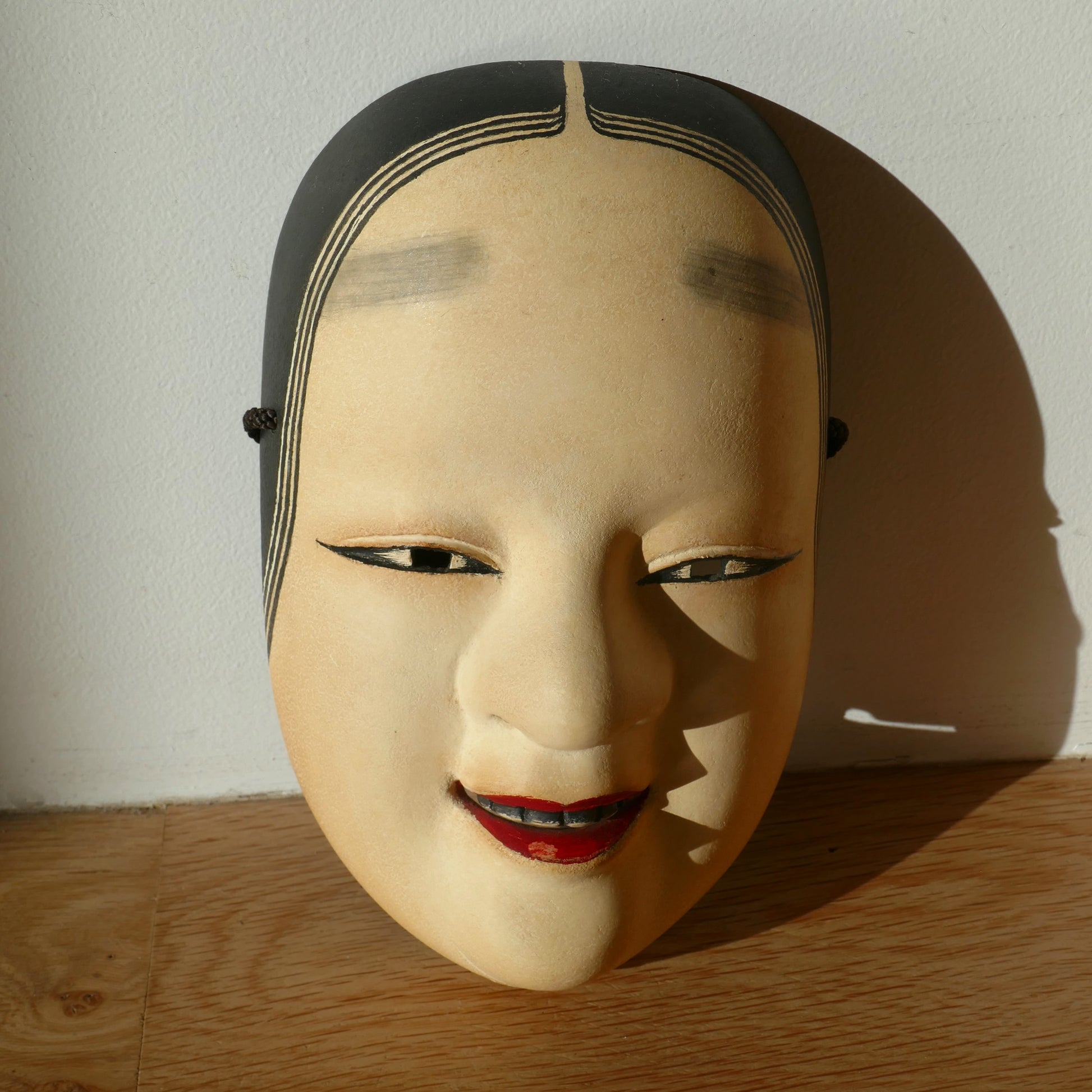 Masque Nō Ko-omote éclairé par le soleil – ombre portée sur le visage
