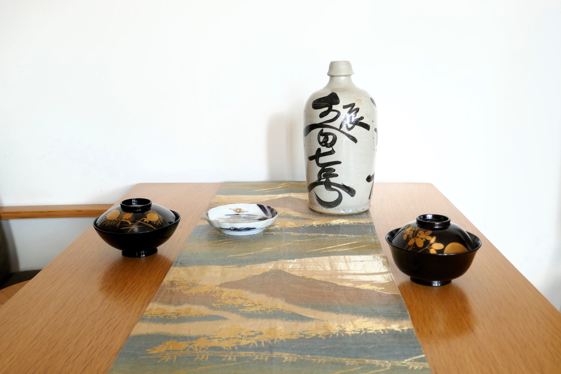 Table japonaise avec mise en scène de bols en laque noire et bouteille de saké – ambiance traditionnelle japonaise sélectionnée par KOGEDO