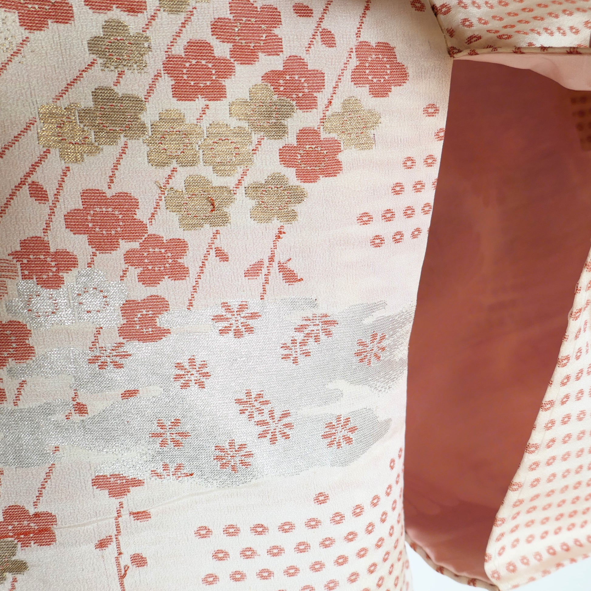 Broderie en soie représentant des ume sur fond rose saumoné à motifs petites fleurs