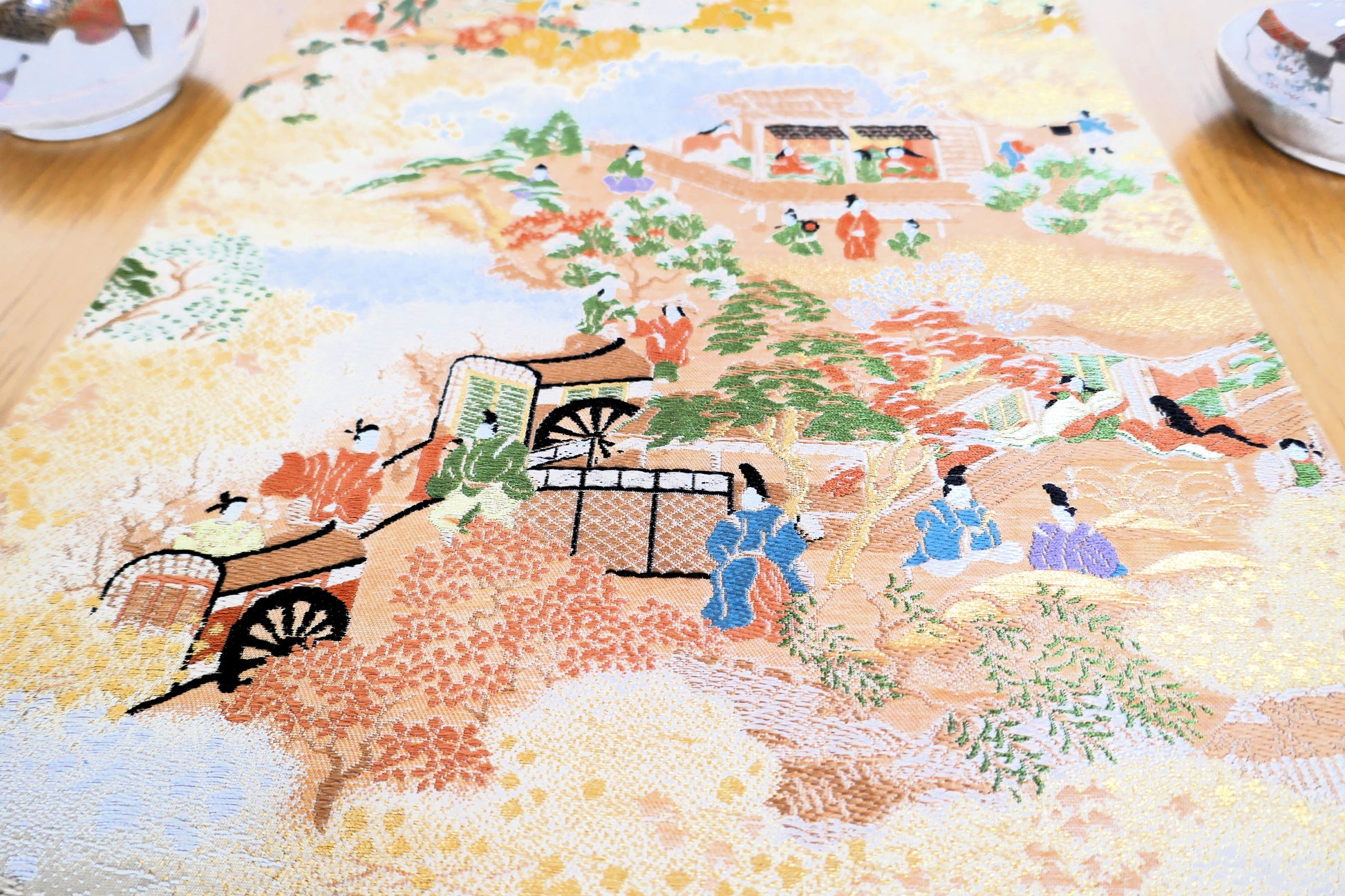 zoom sur le motif du maru obi kogedo scene de vie représentant des charrettes et des hommes