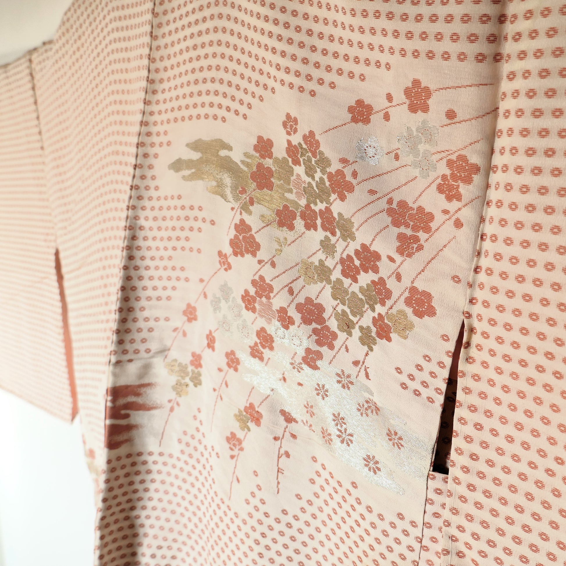 Gros plan sur les fleurs de prunier tissées en soie sur le haori.