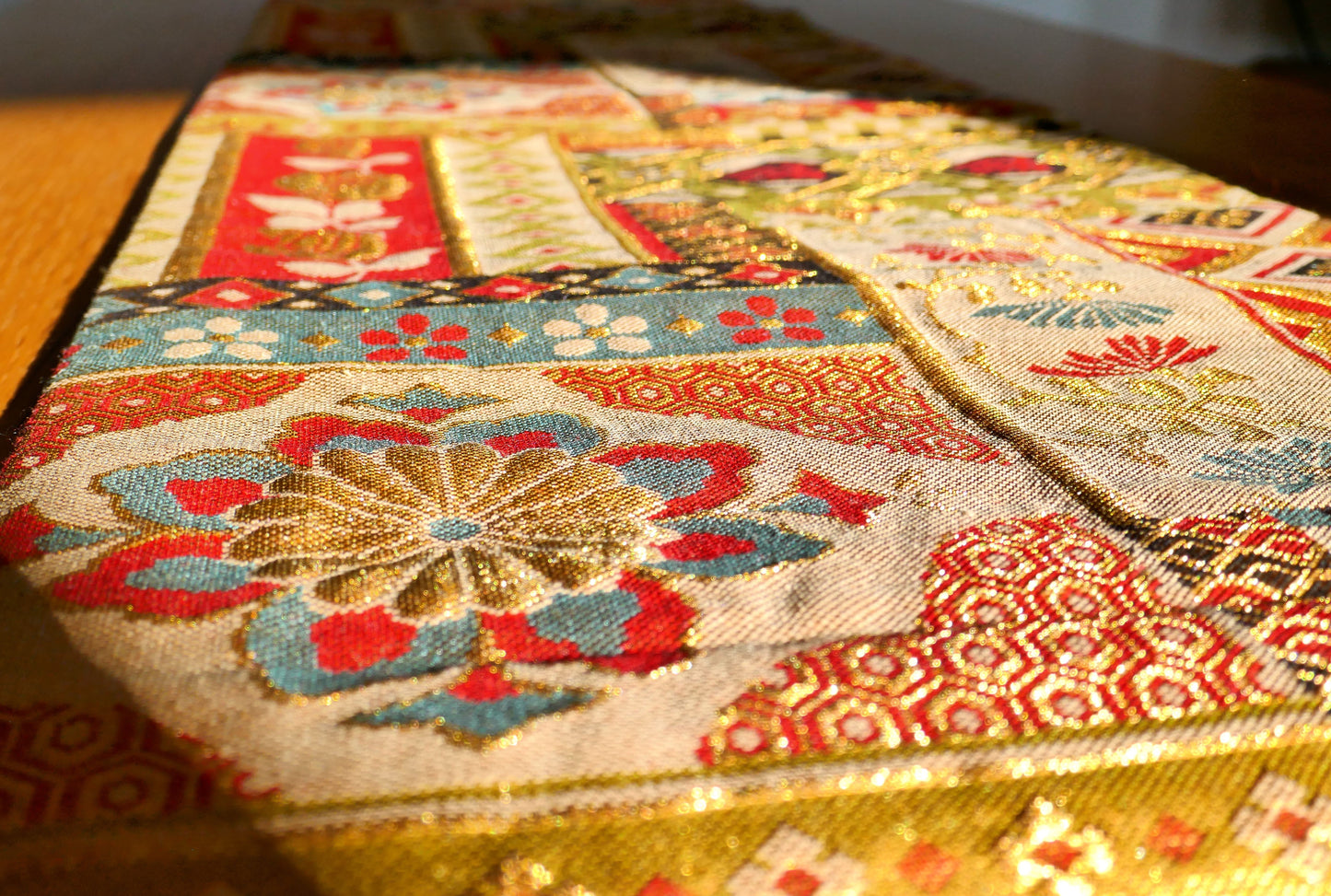Détail sur un chrysanthème multicolore tissé sur fond doré d’un obi japonais