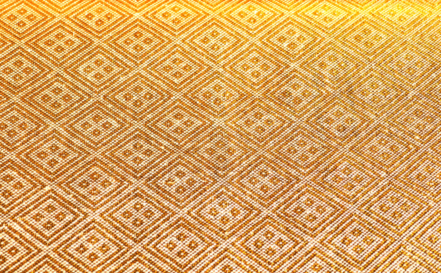 Gros plan du revers d’un obi en soie dorée à motifs de losanges géométriques japonais