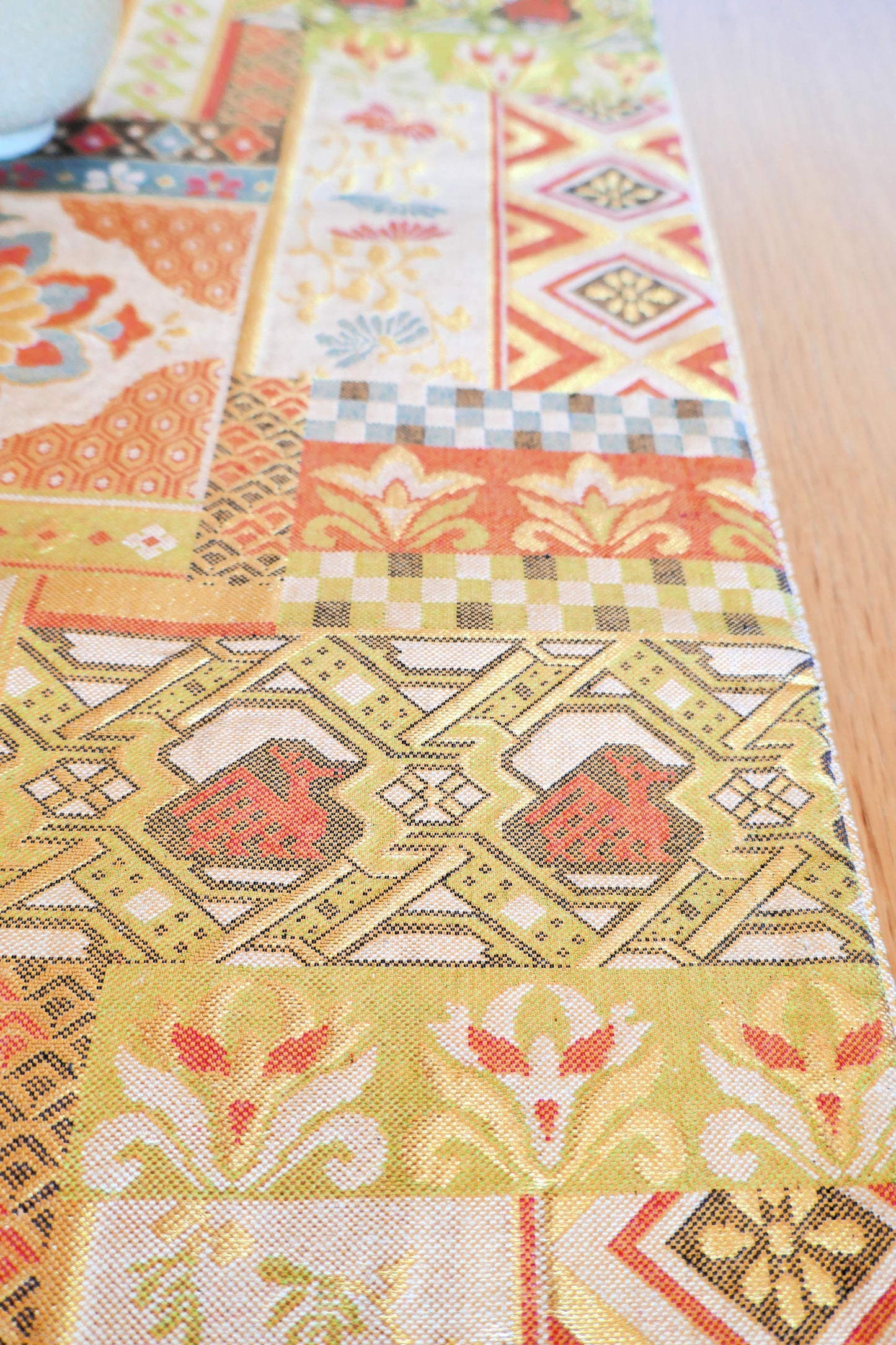 Détail d’un obi ancien en soie avec motifs géométriques oranges stylisés