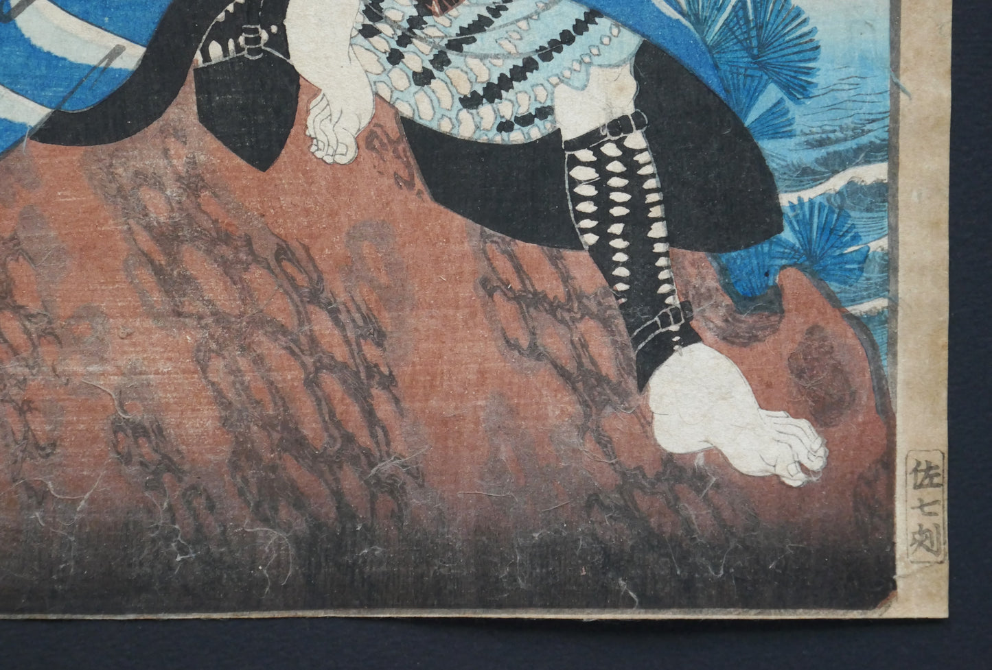 Zoom sur le pied et les vêtements du guerrier Higuchi Jirō Kanemitsu dans une estampe japonaise de Yoshiiku datant de 1863.