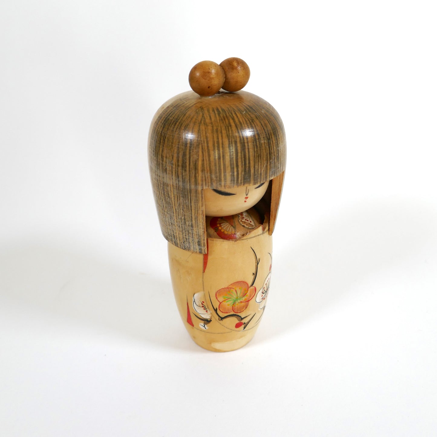 Poupée kokeshi artisanale en bois par Shigemi Tanaka alias Kojo Tanaka, vue de profil / trois-quarts, décor de fleurs de prunier peintes à la main.