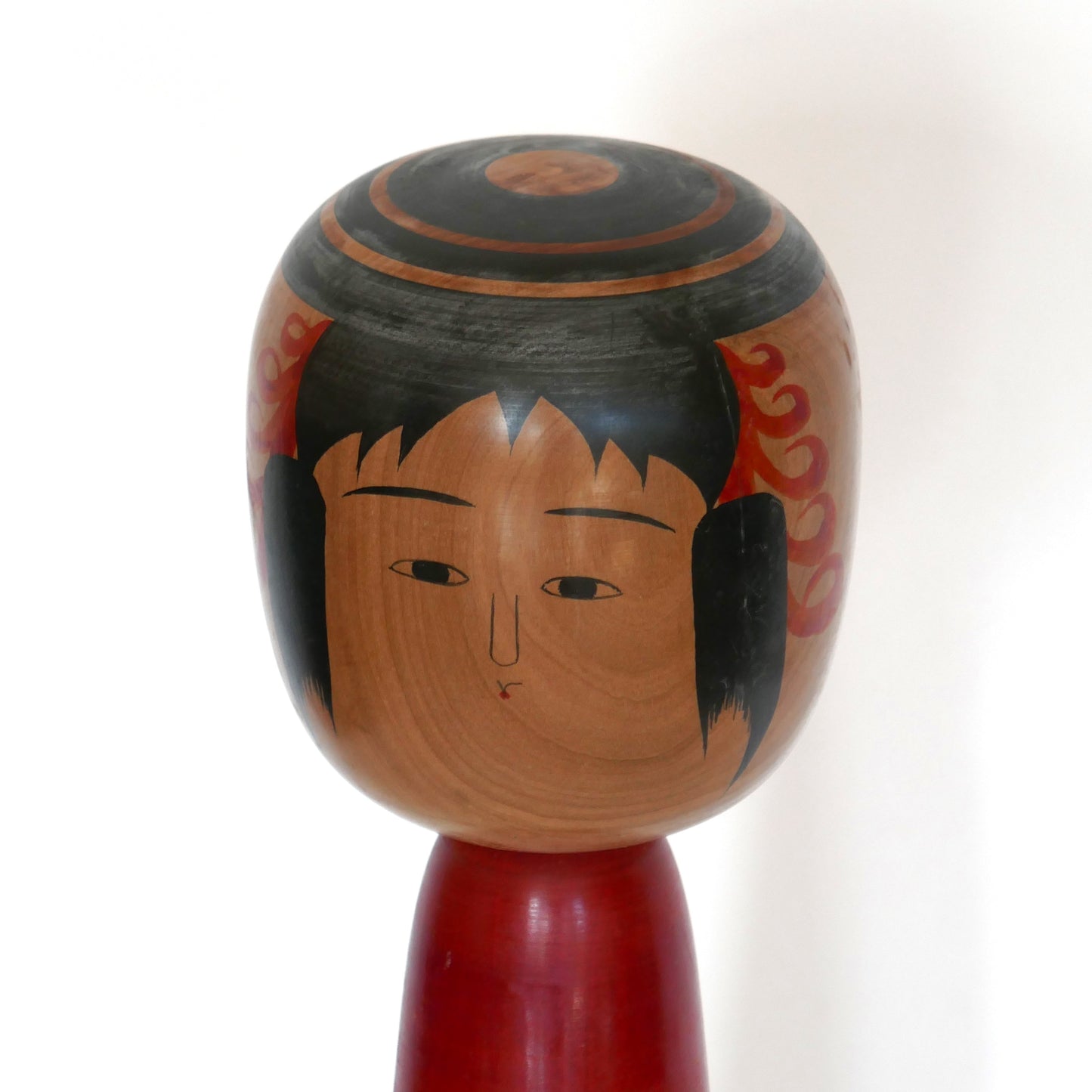 Poupée japonaise traditionnelle Kokeshi, gros plan du visage peint à la main, œuvre de Abe Kazue (style Tsuchiyu).