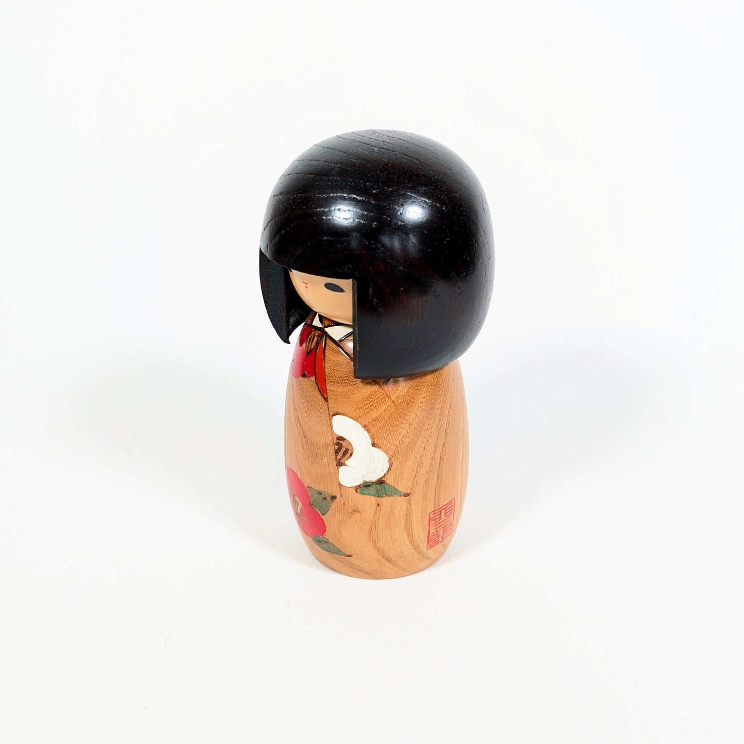 Kokeshi vintage Usaburo Haru no uta vue de profil avec sceau rouge, décor tsubaki et kimono fleuri