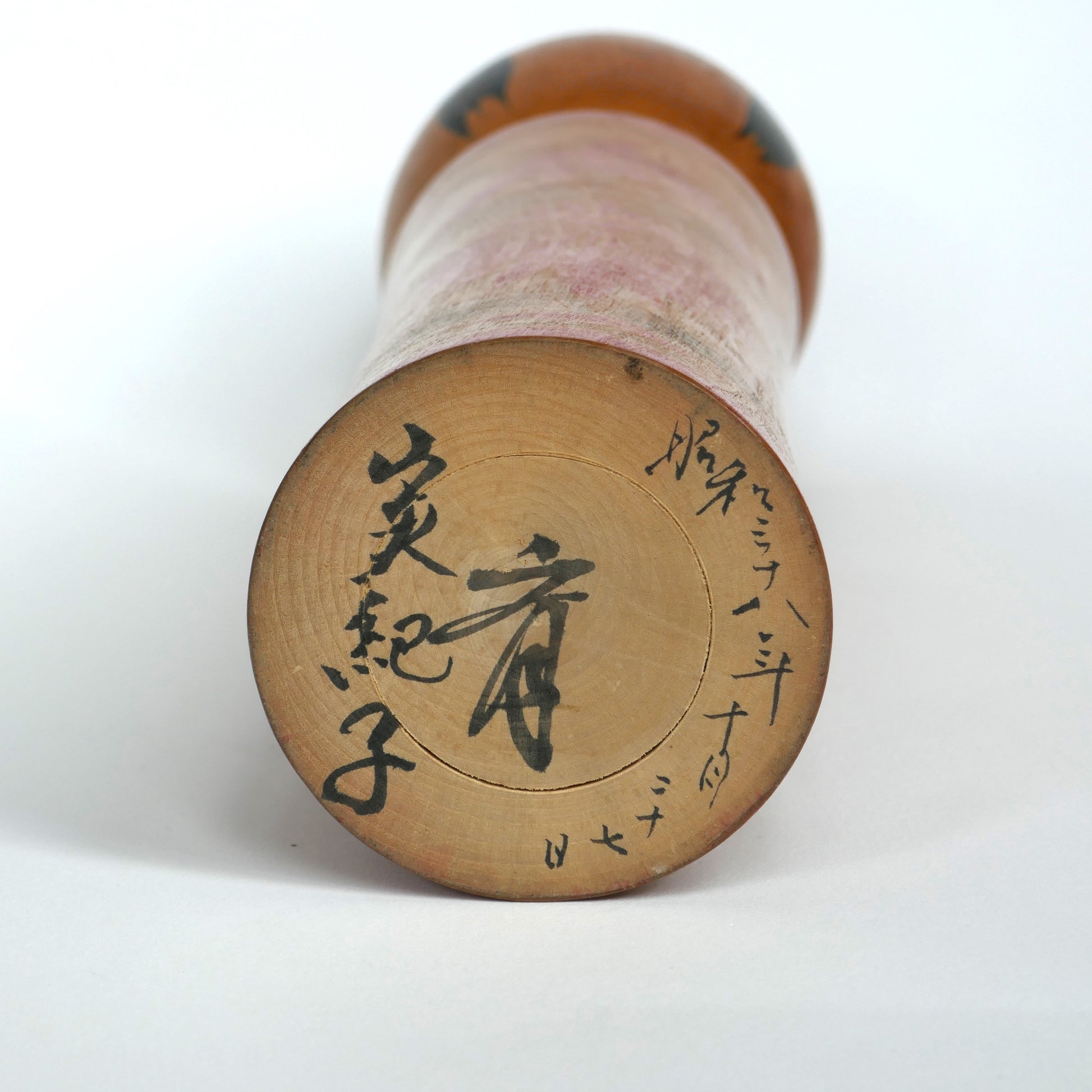 Signature manuscrite d’Okazaki Hitoshi inscrite sous une kokeshi de 1963.