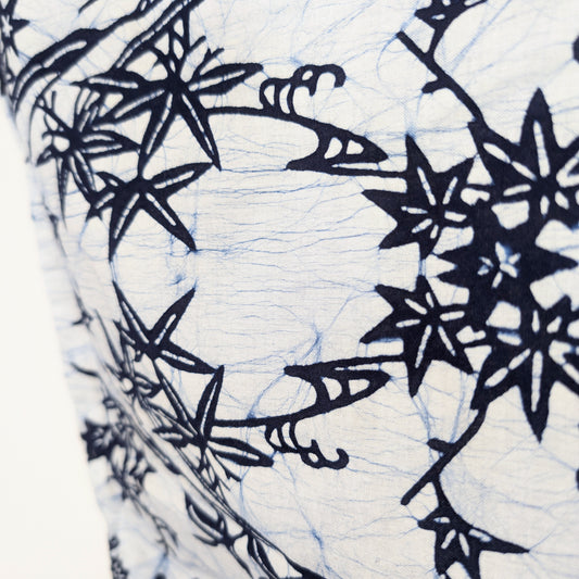 Gros plan du tissu d’un yukata japonais blanc avec motifs bleu indigo de bambou sasa, momiji et fleurs