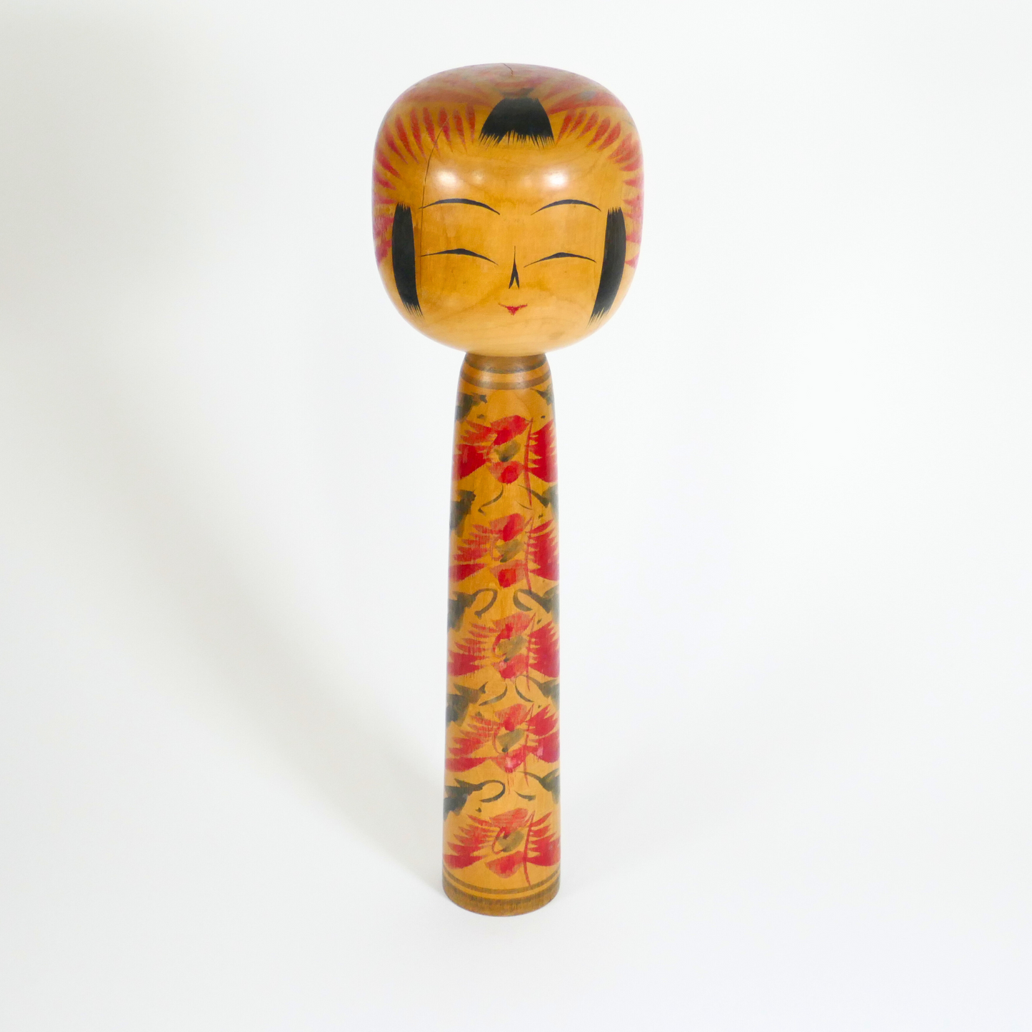 une kokeshi vintage en bois de style Tôgatta, sculptée, peinte à la main et signée par l'artisan Sato Teruo vue de face