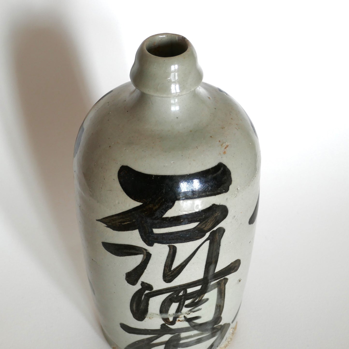 Vue en plongée sur la calligraphie « Ishikawa » (石川酒店) sur tokkuri japonais vintage en grès émaillé de l’ère Shōwa